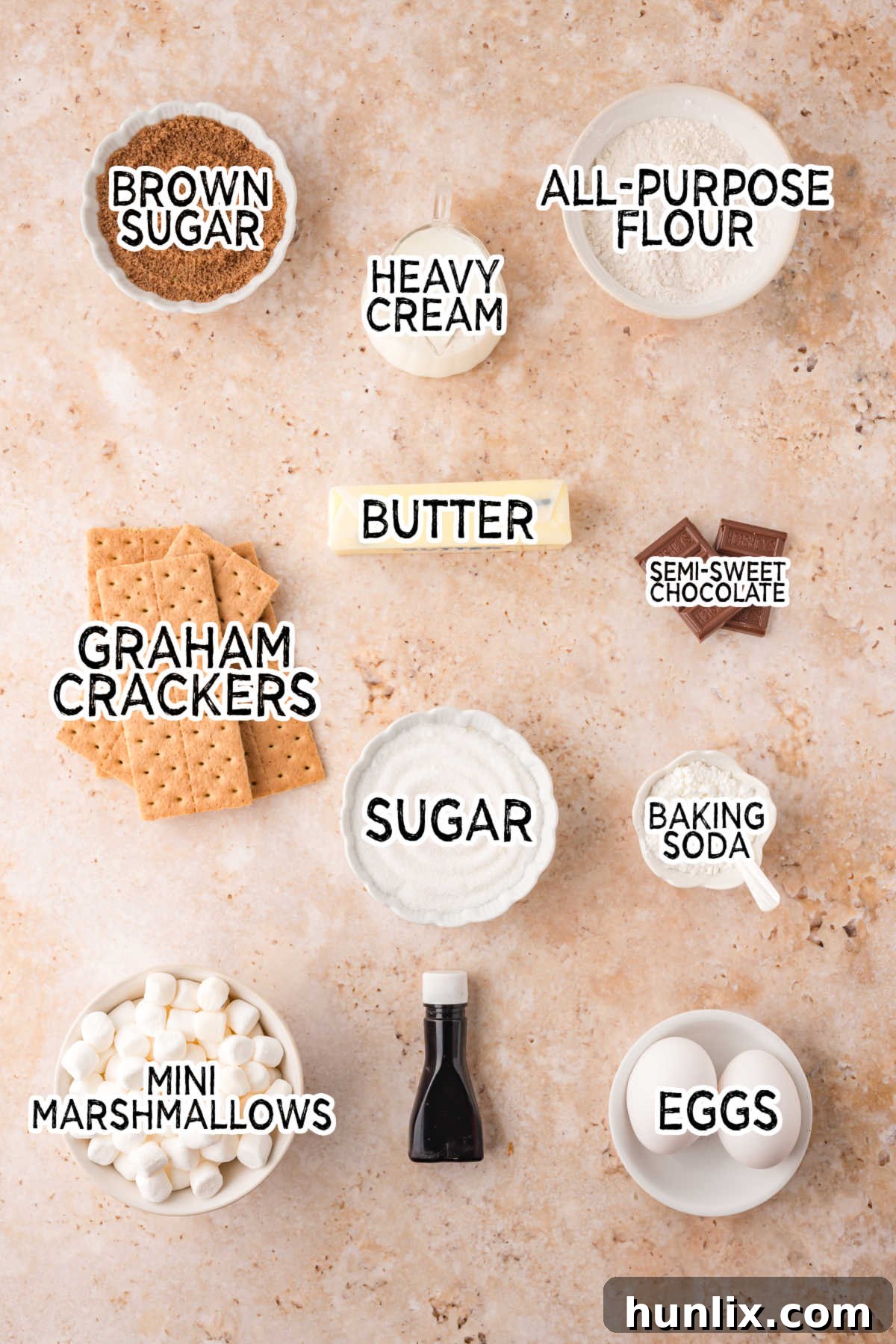 All the s'mores cake ingredients neatly arranged on a beige background.