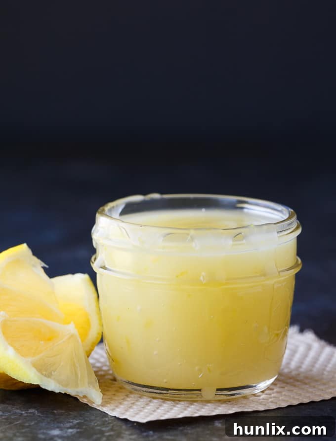 Bright Lemon Elixir 2 Homemade Lemon Sauce for desserts, featuring a vibrant yellow hue and smooth texture, ready to be served over various treats.