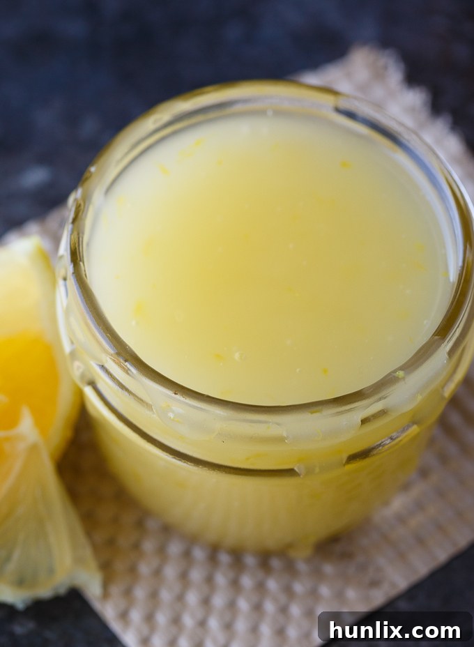 Bright Lemon Elixir 3 Versatile Lemon Sauce in a glass jar, perfect for topping ice cream, cake, bread pudding, or pancakes.