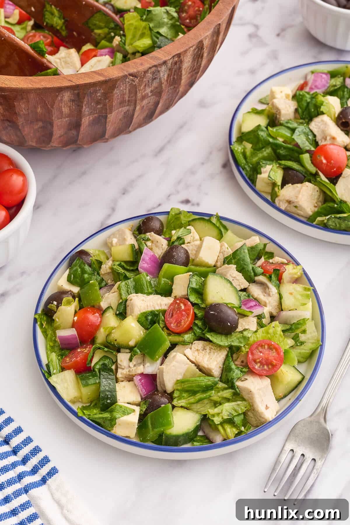 The Greek Chicken Salad beautifully presented on a white plate, highlighting its fresh components.