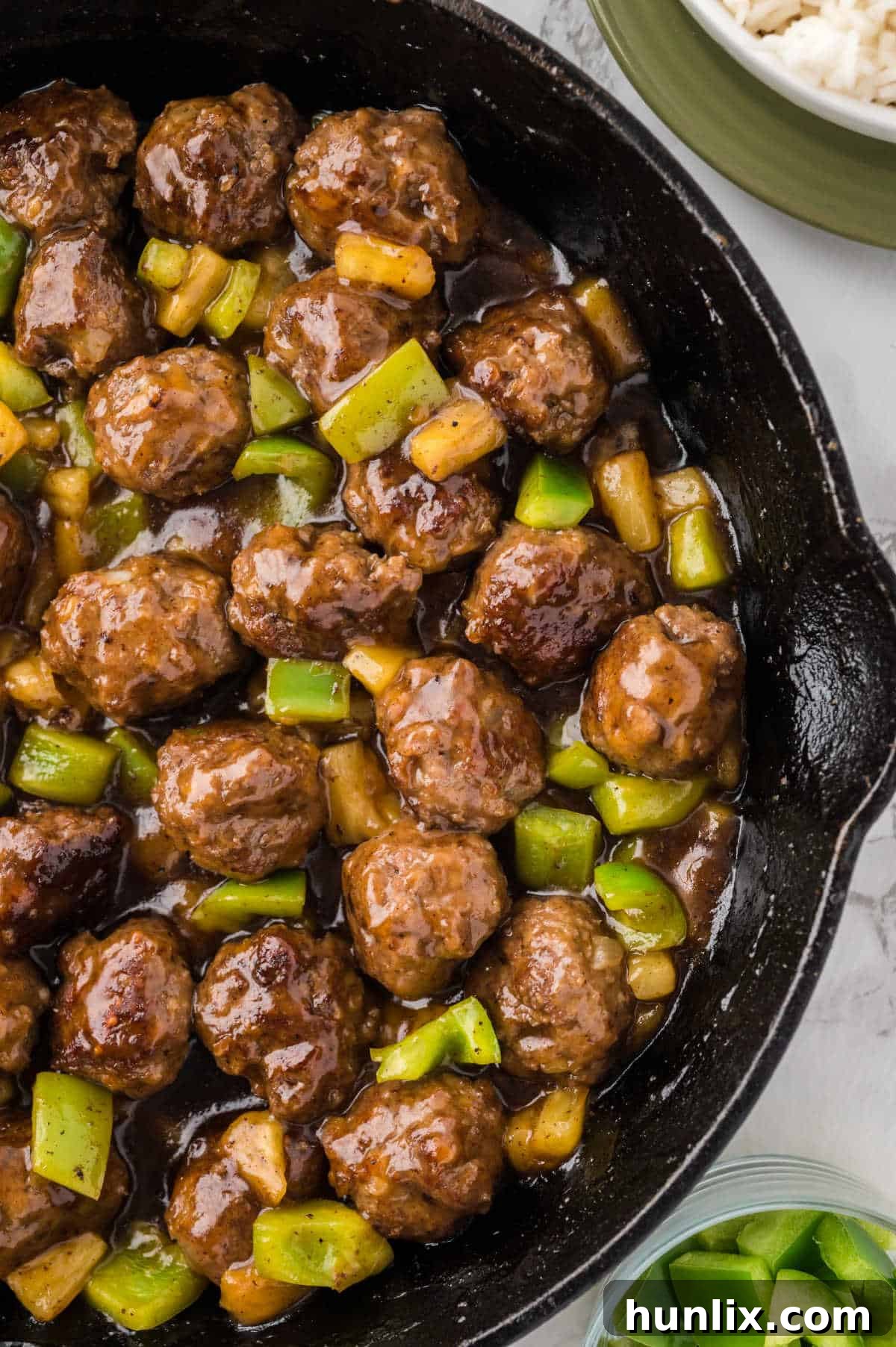 A skillet full of Waikiki meatballs, perfectly cooked and glistening with the sweet and sour pineapple sauce.