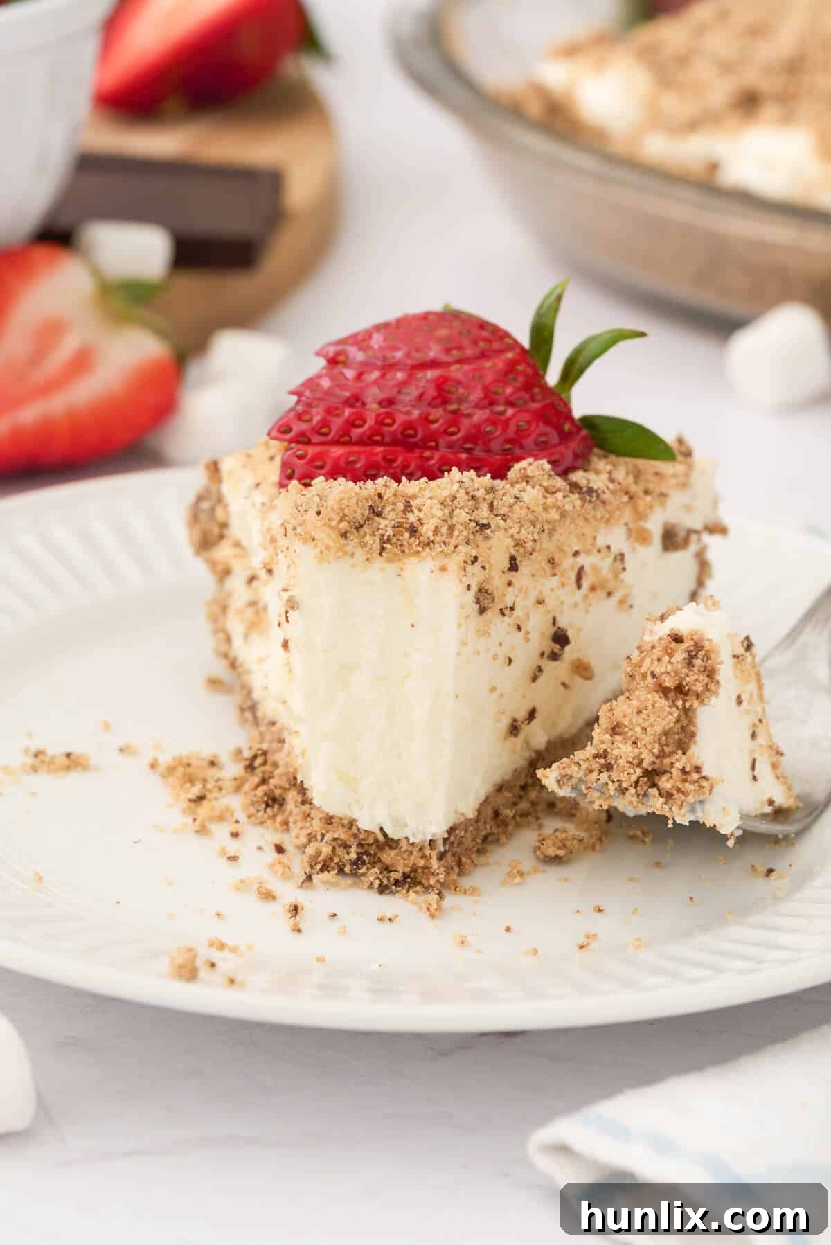 A close-up shot of a slice of Marshmallow Pie on a plate, with a small bite taken, revealing its incredibly soft, airy interior and inviting texture.