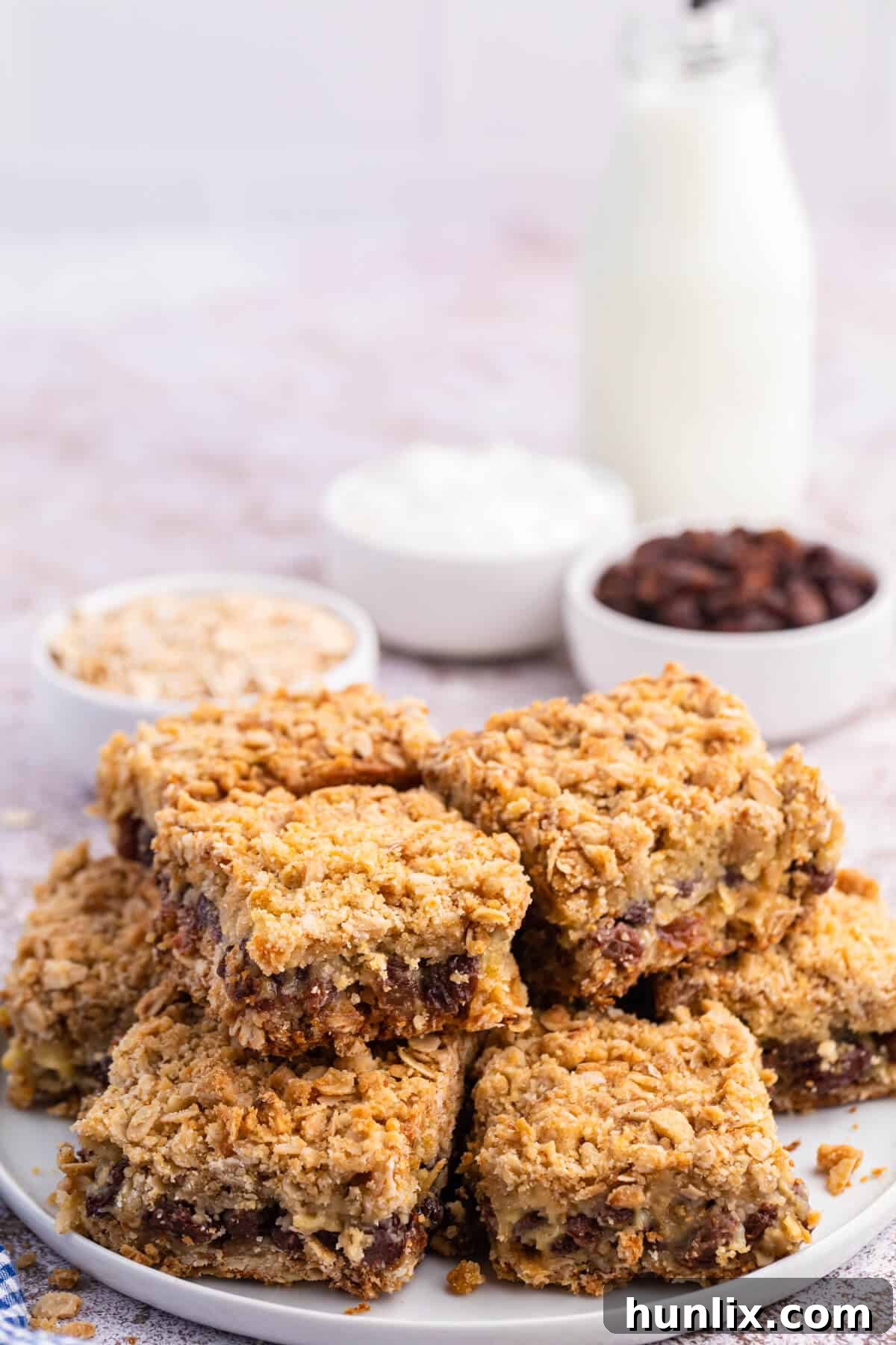 Sweet and Tangy Raisin Bars 6 A group of sour cream raisin bars stacked on a plate.