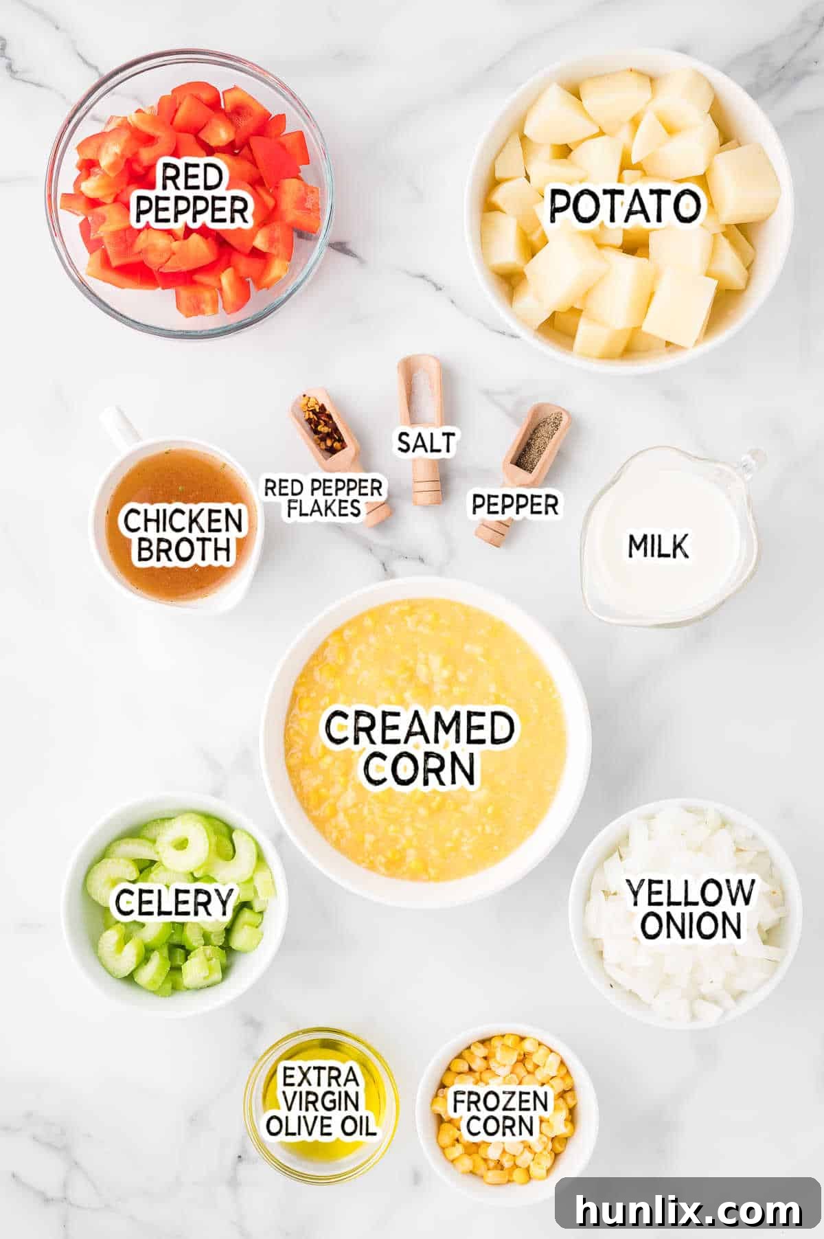 Sunshine Corn Chowder 3 Various fresh ingredients laid out on a wooden board, including corn on the cob, potatoes, onions, and bell peppers, ready to be transformed into a delicious homemade corn chowder.