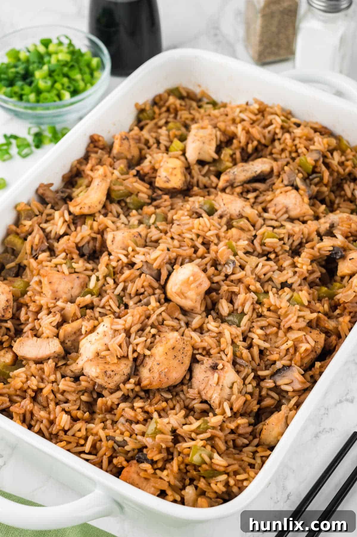 A large casserole dish filled with golden-brown oven baked chicken fried rice, ready to be served.