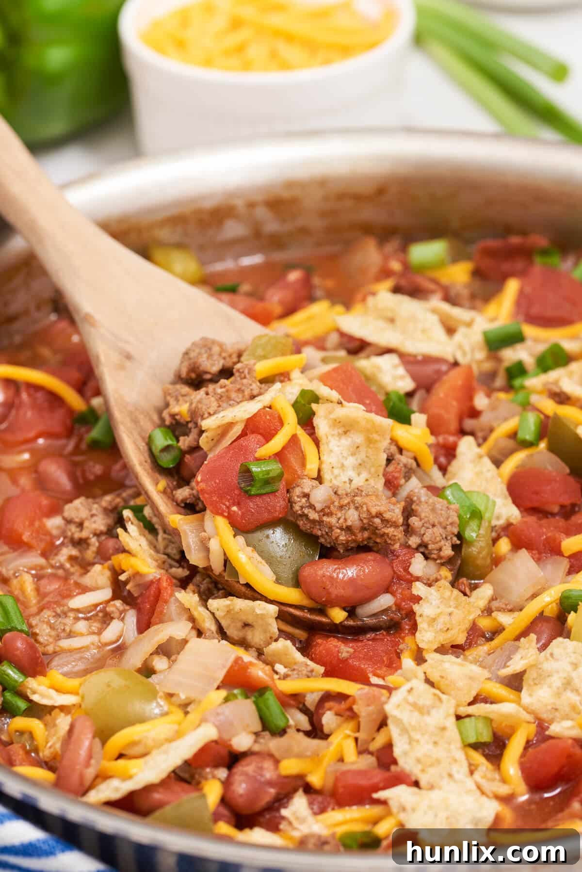 Cowboy Skillet Supper 6 Texas beef skillet in a pan with a wooden serving spoon.