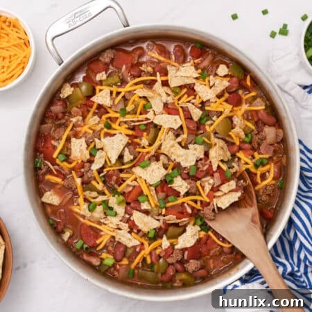 Cowboy Skillet Supper 9 Texas beef skillet in a pan with a wooden serving spoon.