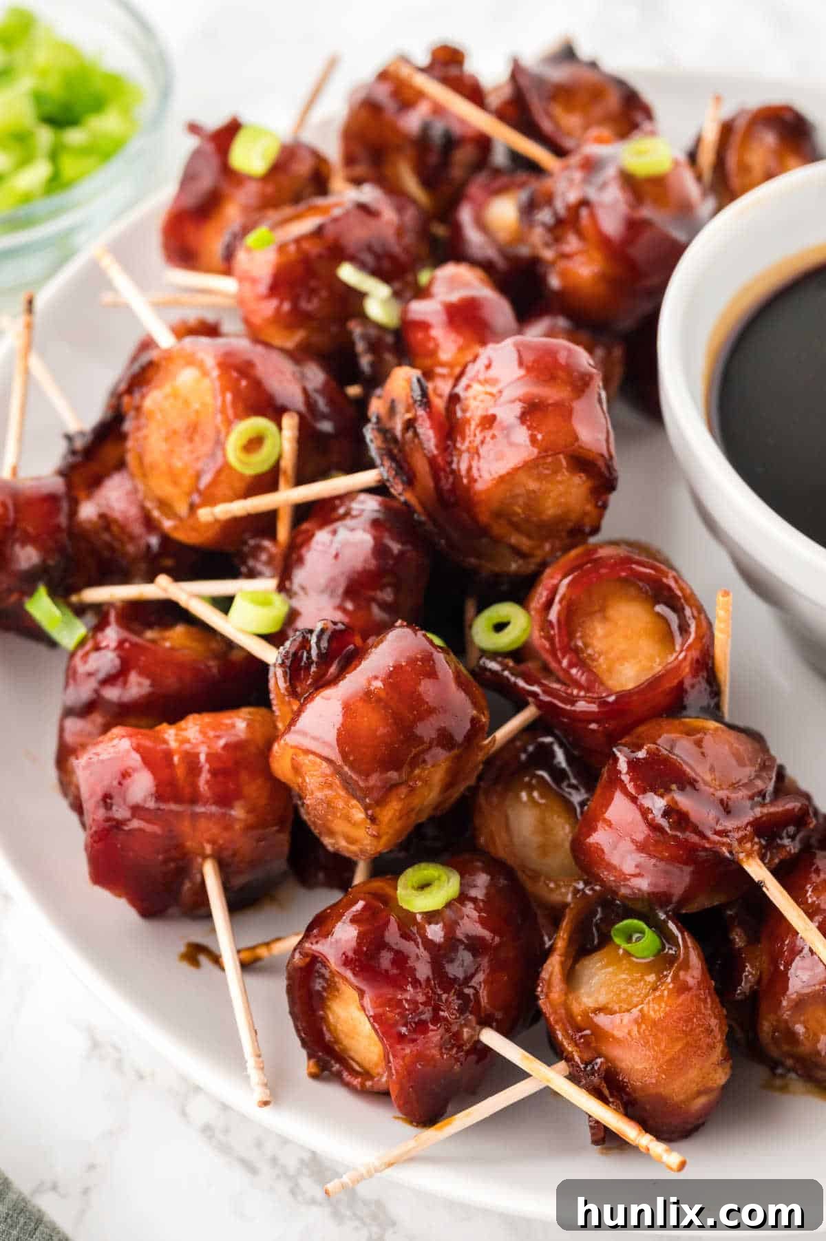 Crispy Bacon Wrapped Water Chestnuts on a pristine white serving platter, ready to be devoured.