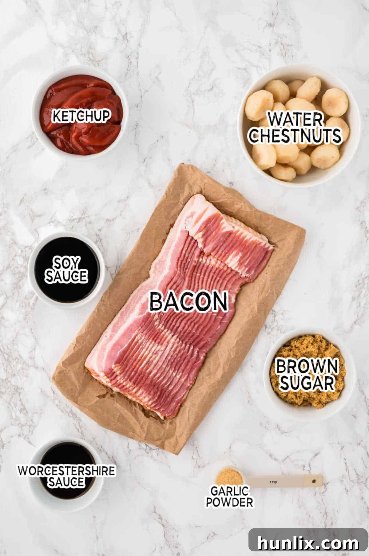 A collection of fresh ingredients laid out on a clean surface, ready for preparing bacon wrapped water chestnuts: bacon strips, canned water chestnuts, brown sugar, Worcestershire sauce, soy sauce, ketchup, and garlic powder.