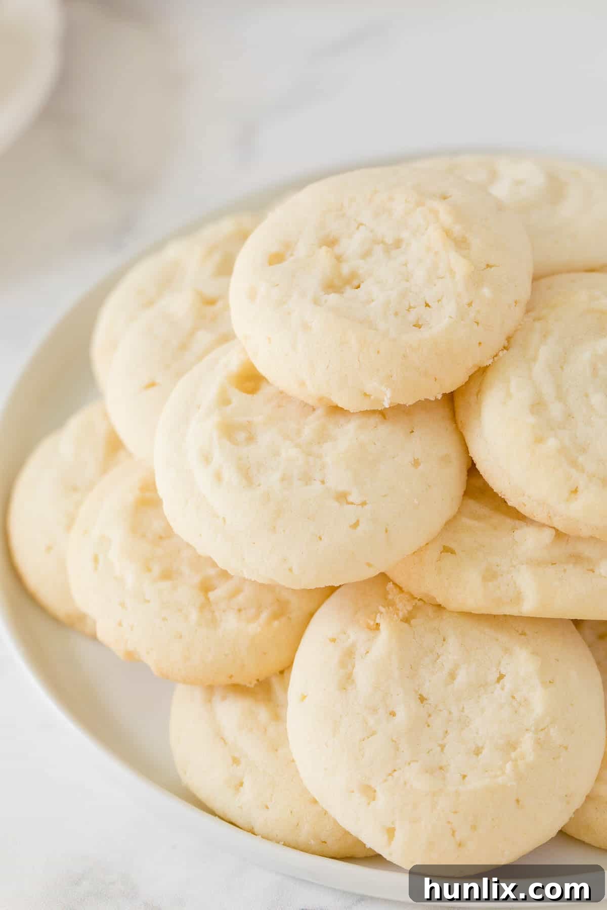 A plate of whipped shortbread cookies, showcasing their delicate and crumbly texture.