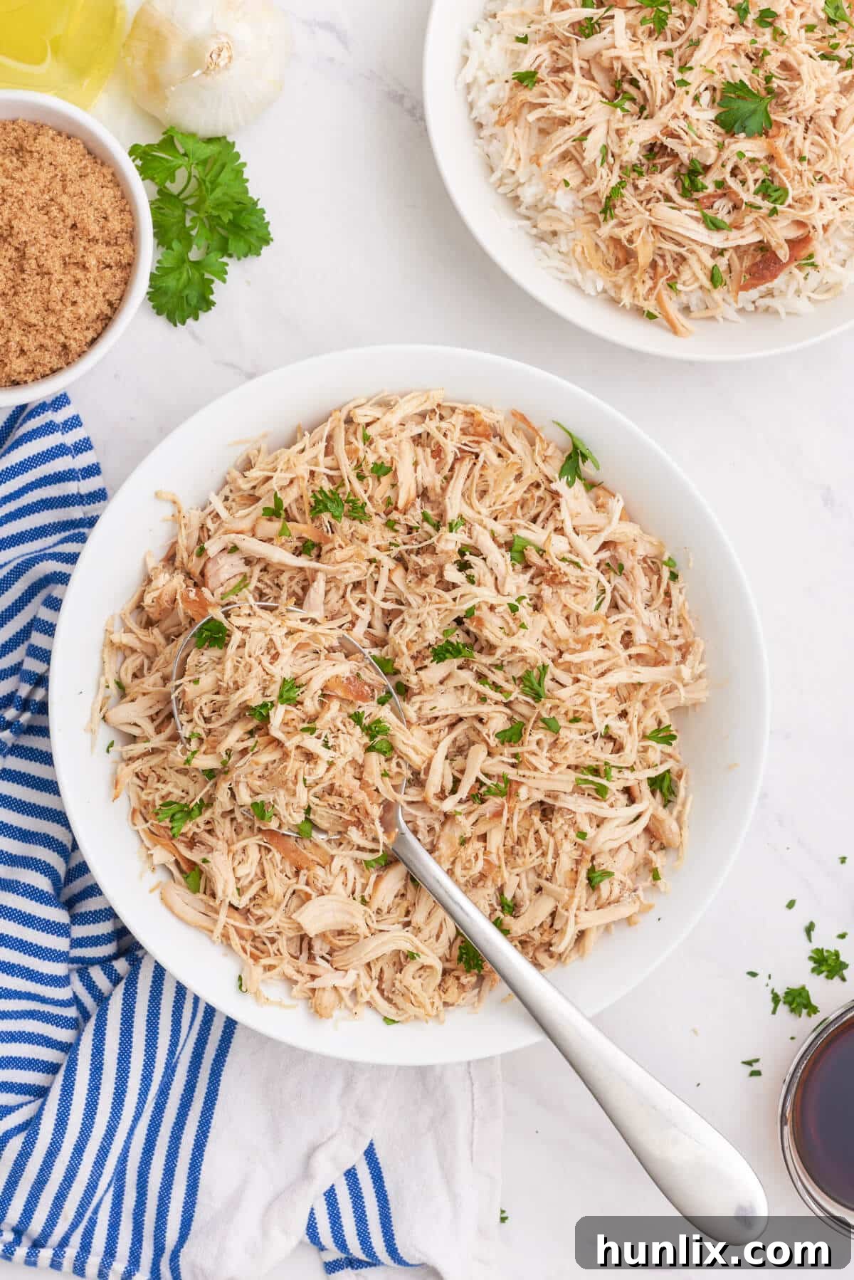 Sticky Sweet Brown Sugar Chicken 2 Brown sugar chicken in a bowl with a serving spoon, garnished with fresh parsley.
