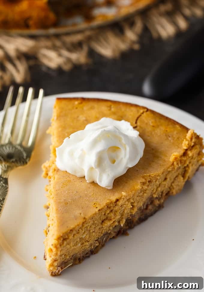 Close-up of a slice of Keto Pumpkin Cheesecake, showing its creamy texture and rich color.
