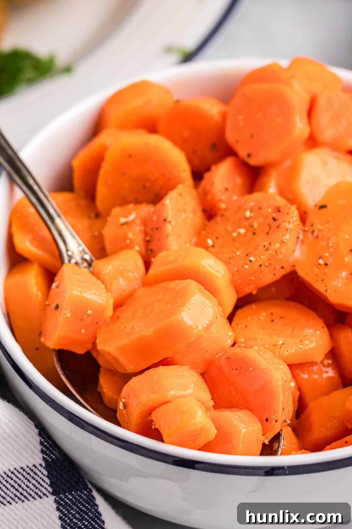 Sweet and sour carrots in a bowl with a spoon.