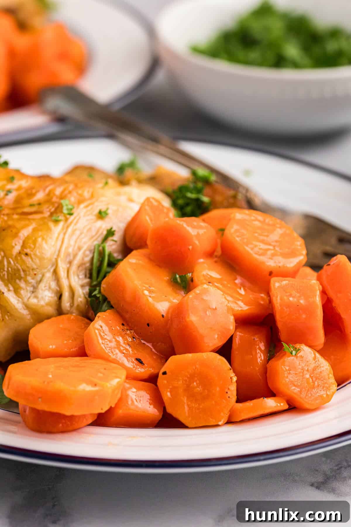 Sweet and sour carrots on a plate with chicken.