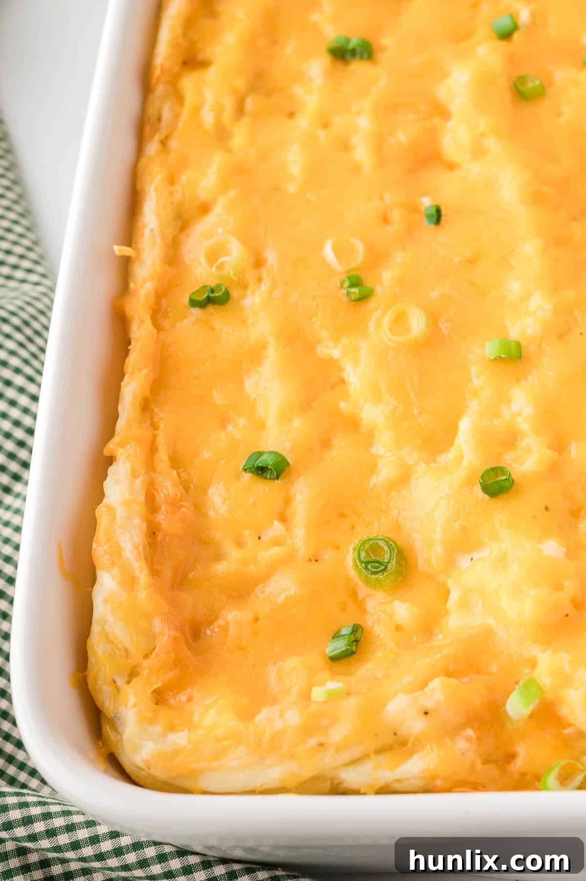 Mashed potato casserole in a white pan, golden brown and bubbling.