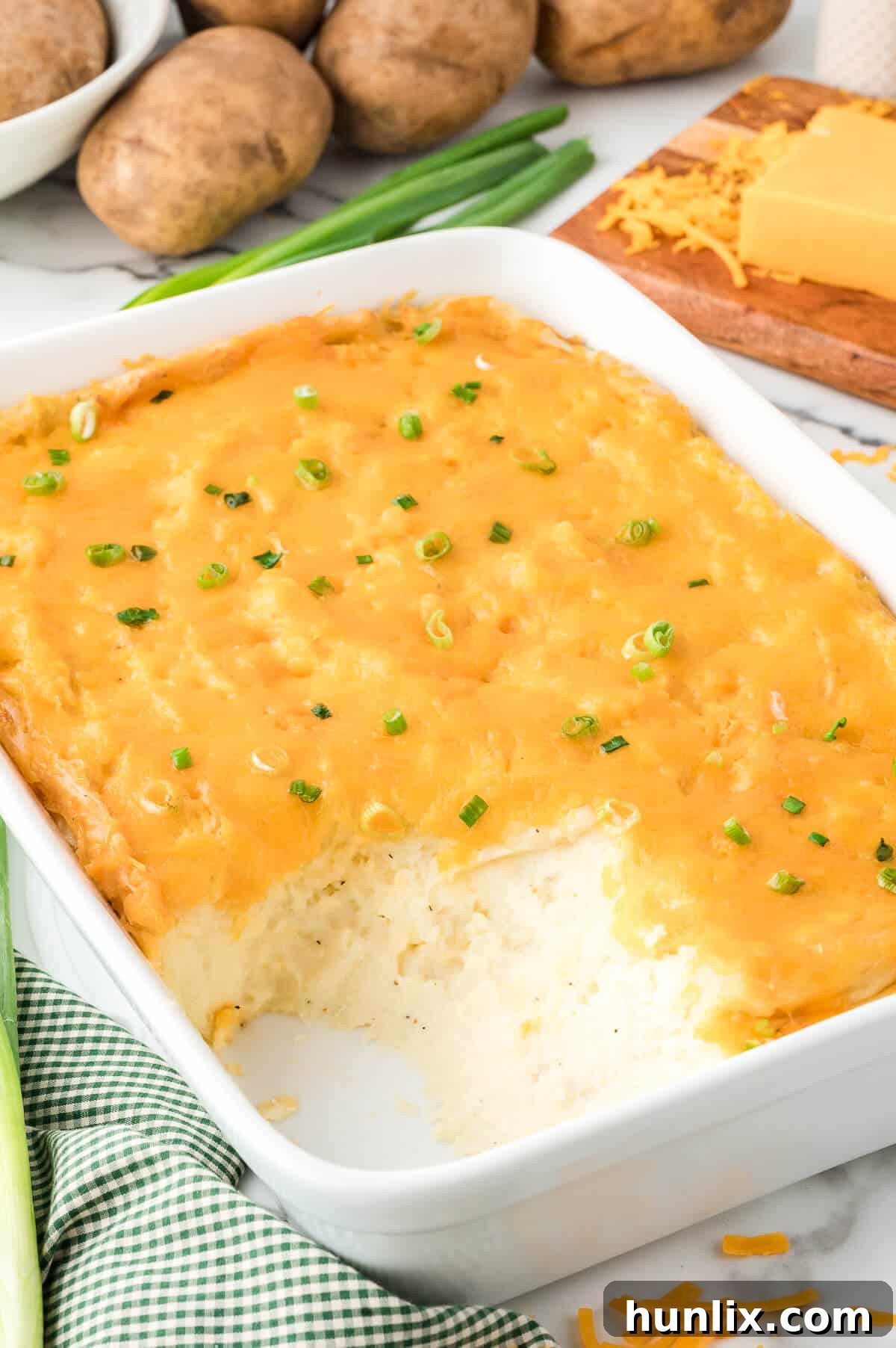 Mashed potato casserole with several scoops removed, showing the creamy interior.