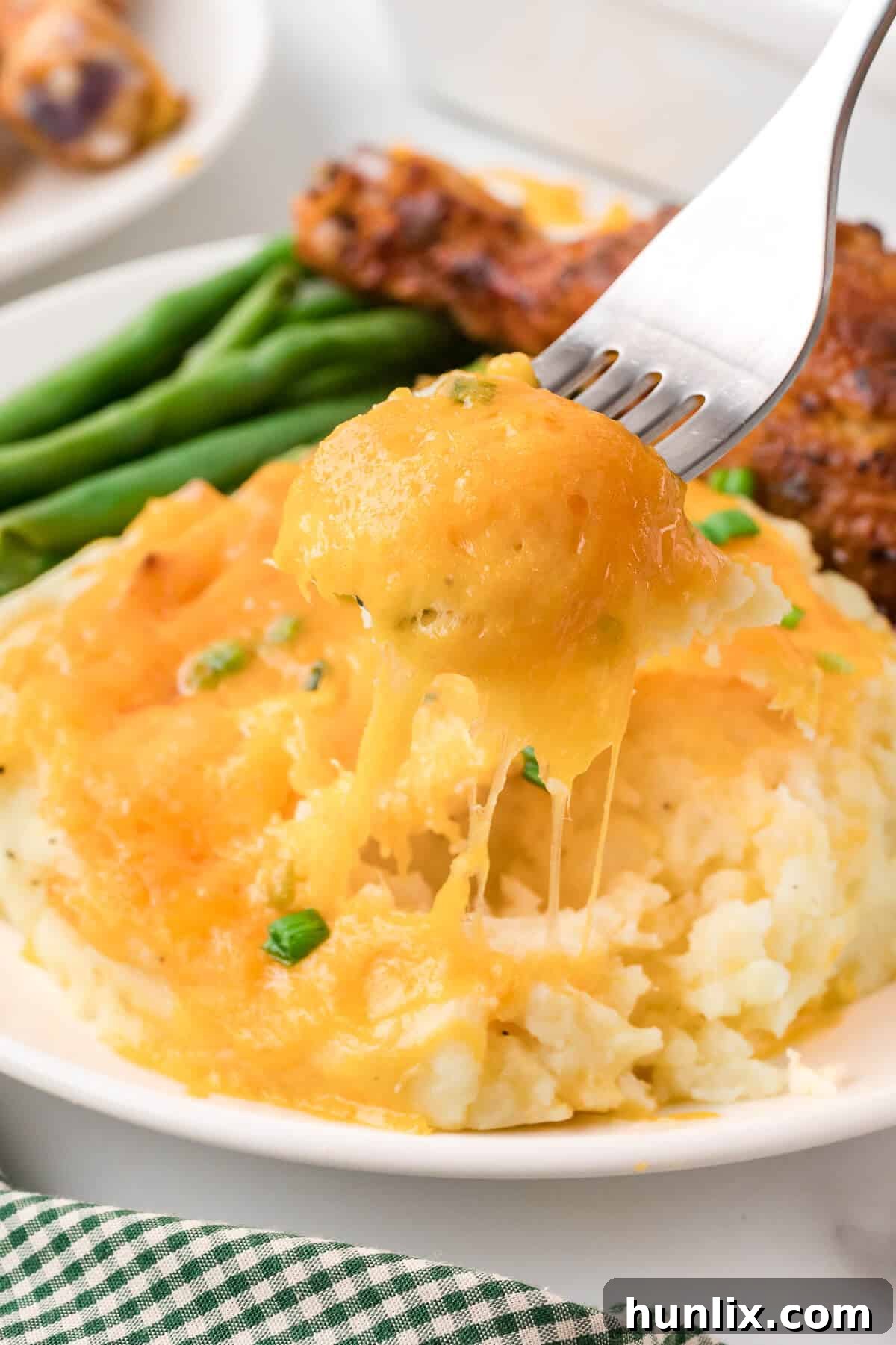 A serving of mashed potato casserole on a white plate with a fork.