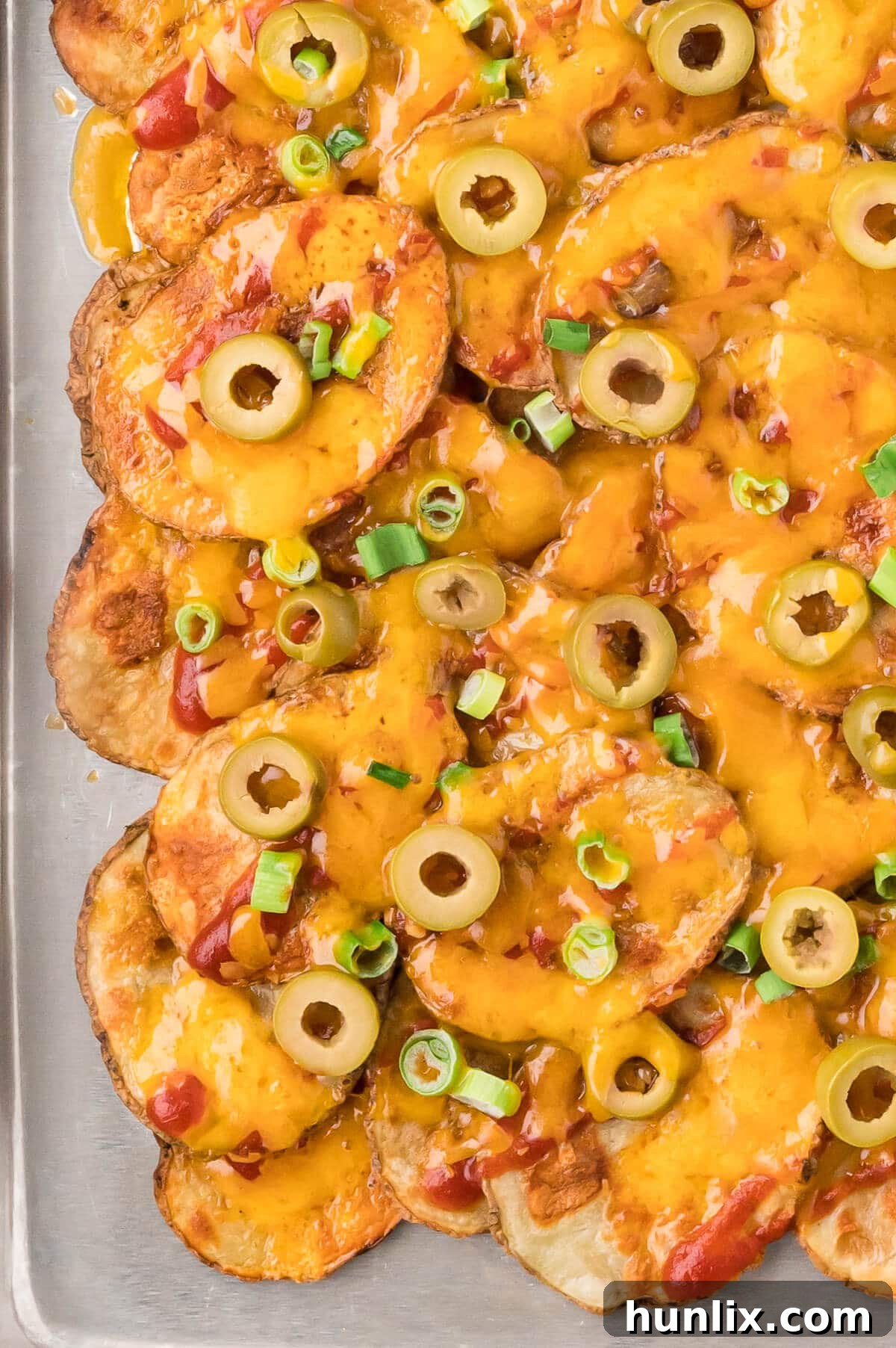 Loaded Potato Nachos 6 A large baking pan filled with golden potato nachos, ready to be served.