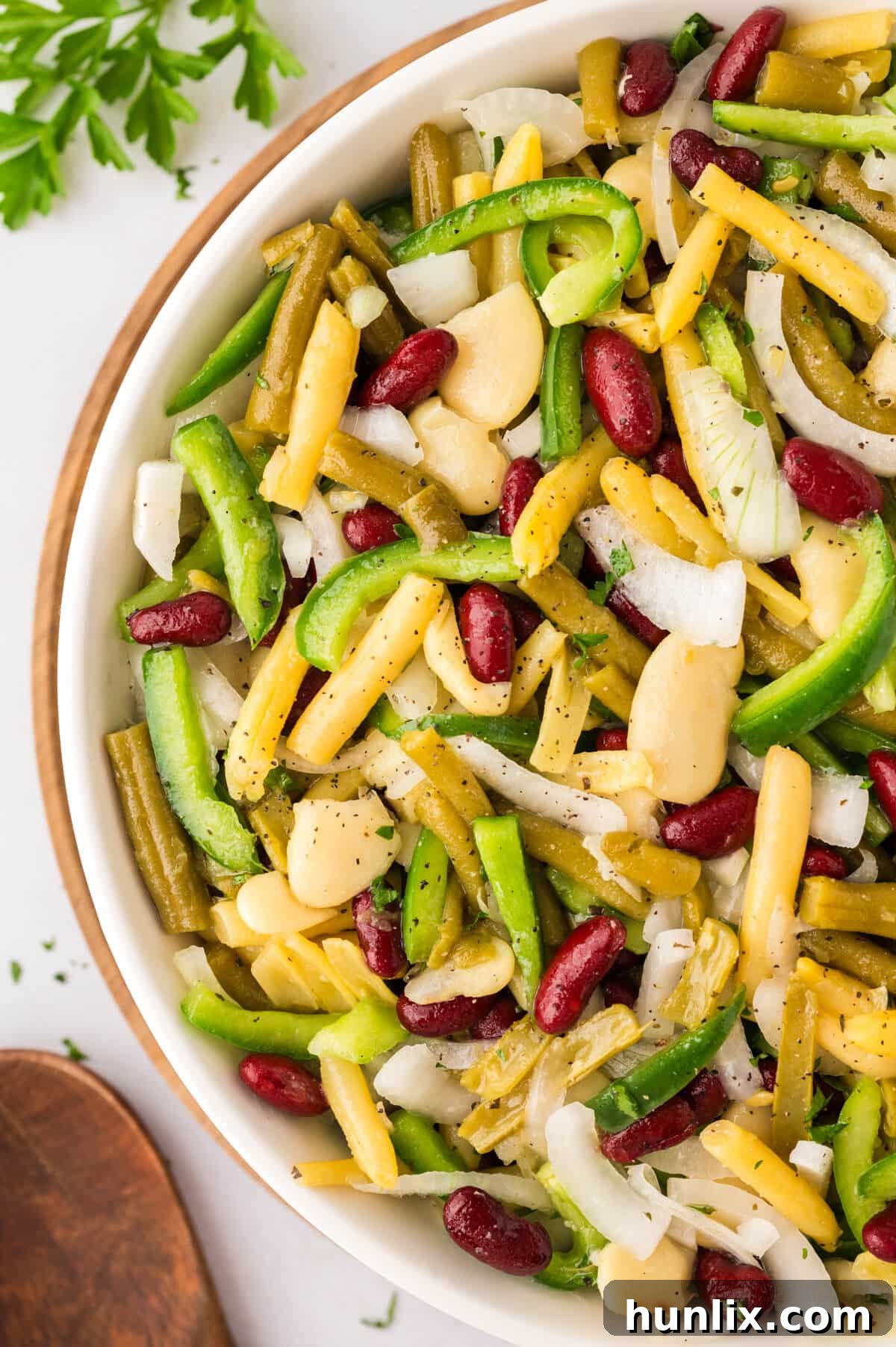 Vibrant Bean Medley 7 The finished bean salad presented beautifully in a large, elegant clear glass bowl, showcasing its colorful layers and inviting textures.