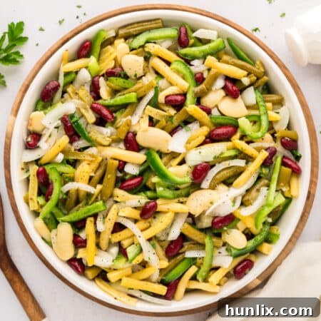 The finished bean salad in a serving bowl, ready to be enjoyed with a fork.