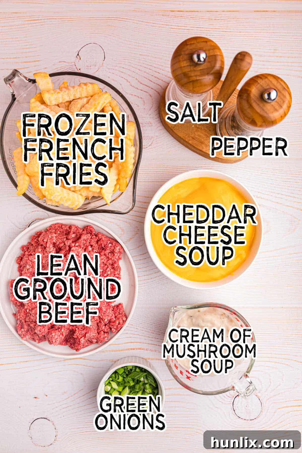 Crispy Spud Bake 3 Various ingredients for French Fry Casserole laid out on a counter: ground beef, canned soups, frozen fries, and green onions, ready for assembly.