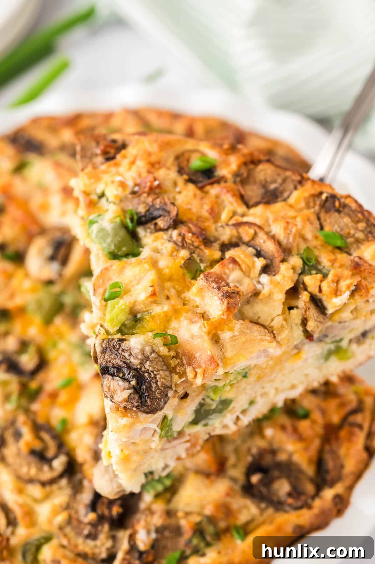 Effortless Chicken Pie 6 A serving of Impossible Chicken Pie being lifted from the pie plate with a spatula, showcasing its perfect crust and savory filling.