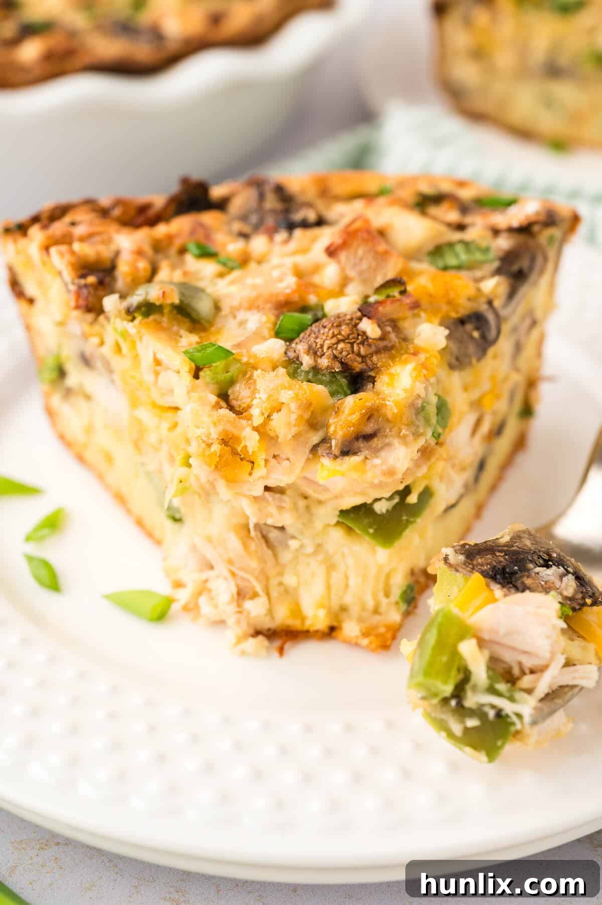 Effortless Chicken Pie 8 A slice of Impossible Chicken Pie on a white plate with a silver fork, ready to be enjoyed.