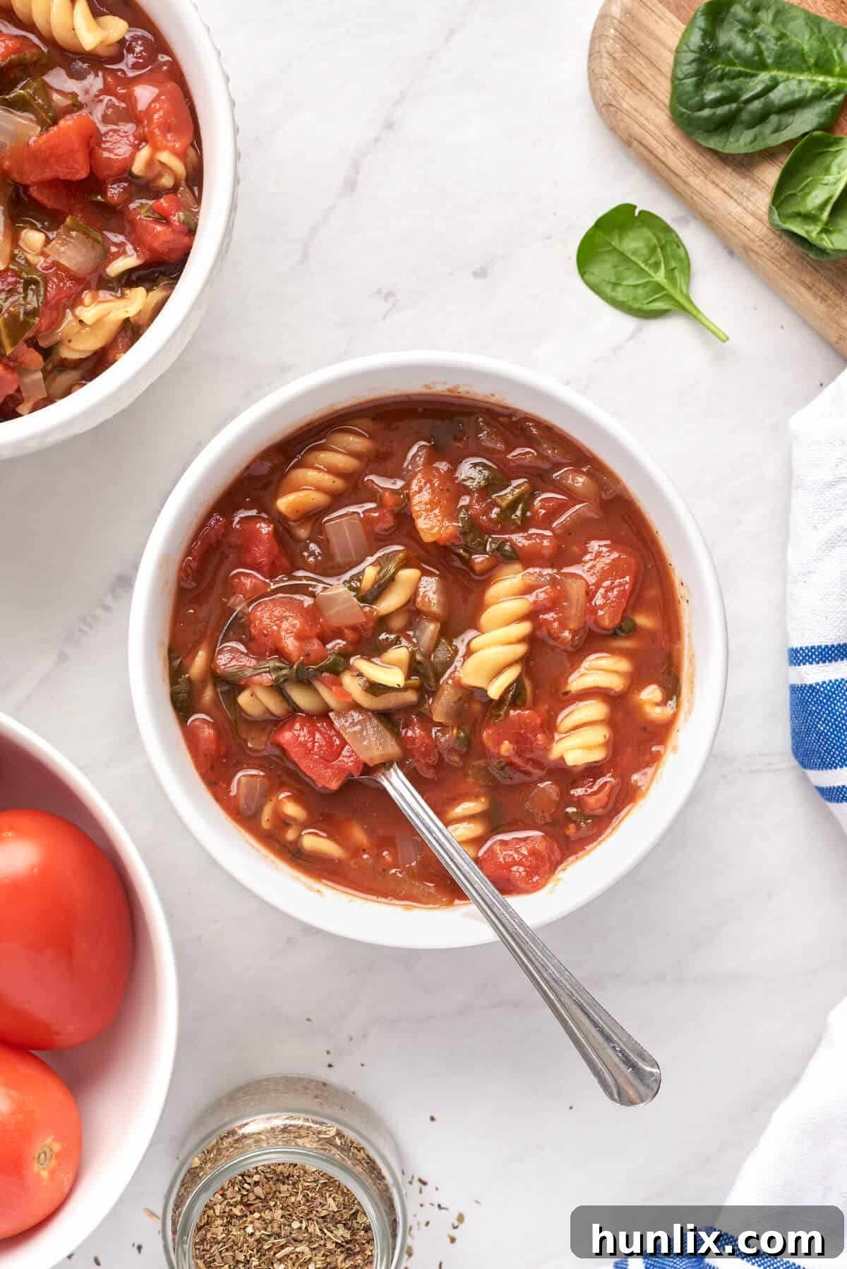 A charming bowl of Tomato Florentine Soup with a spoon, inviting you to take a taste.