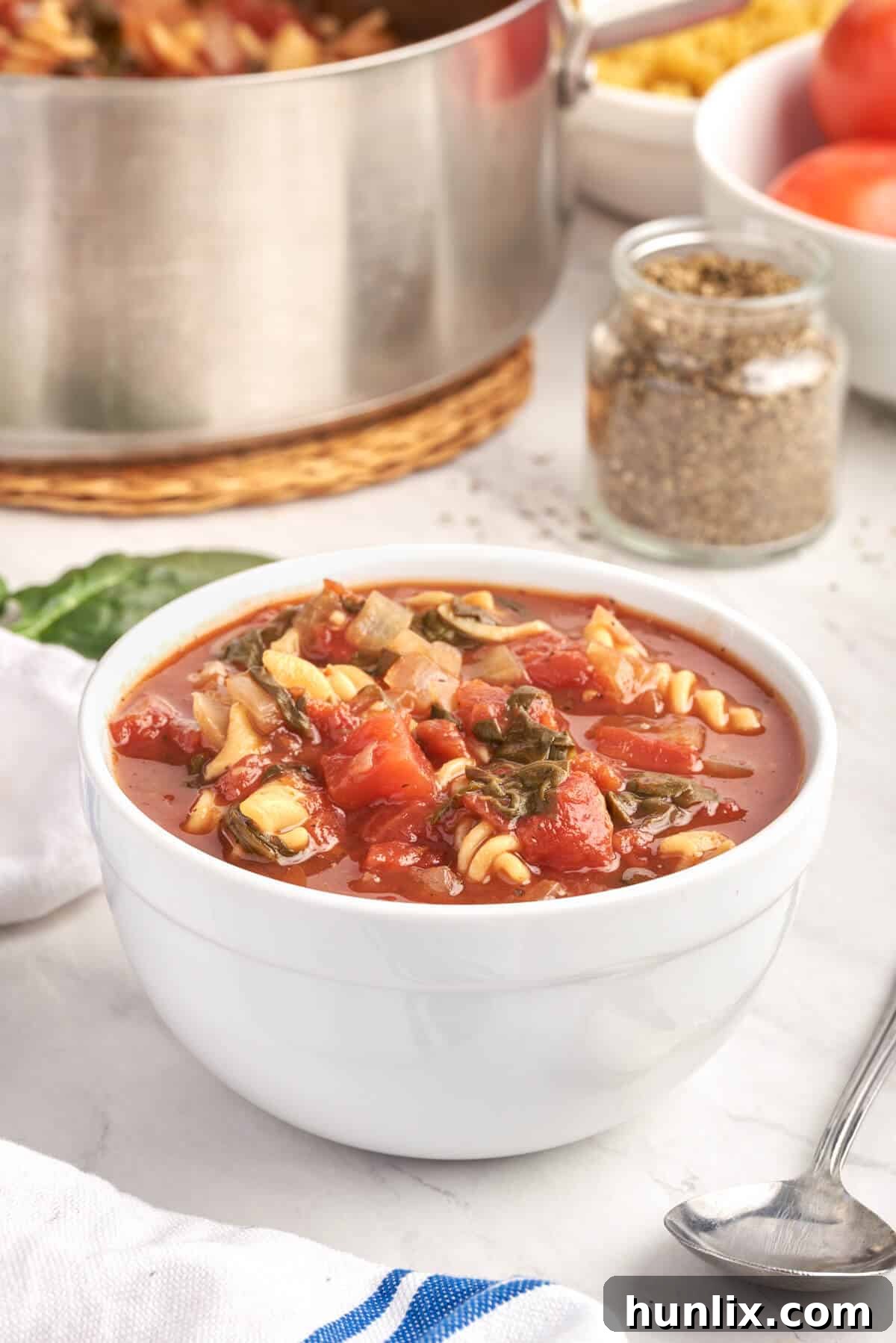 A pristine white bowl filled with vibrant Tomato Florentine Soup.