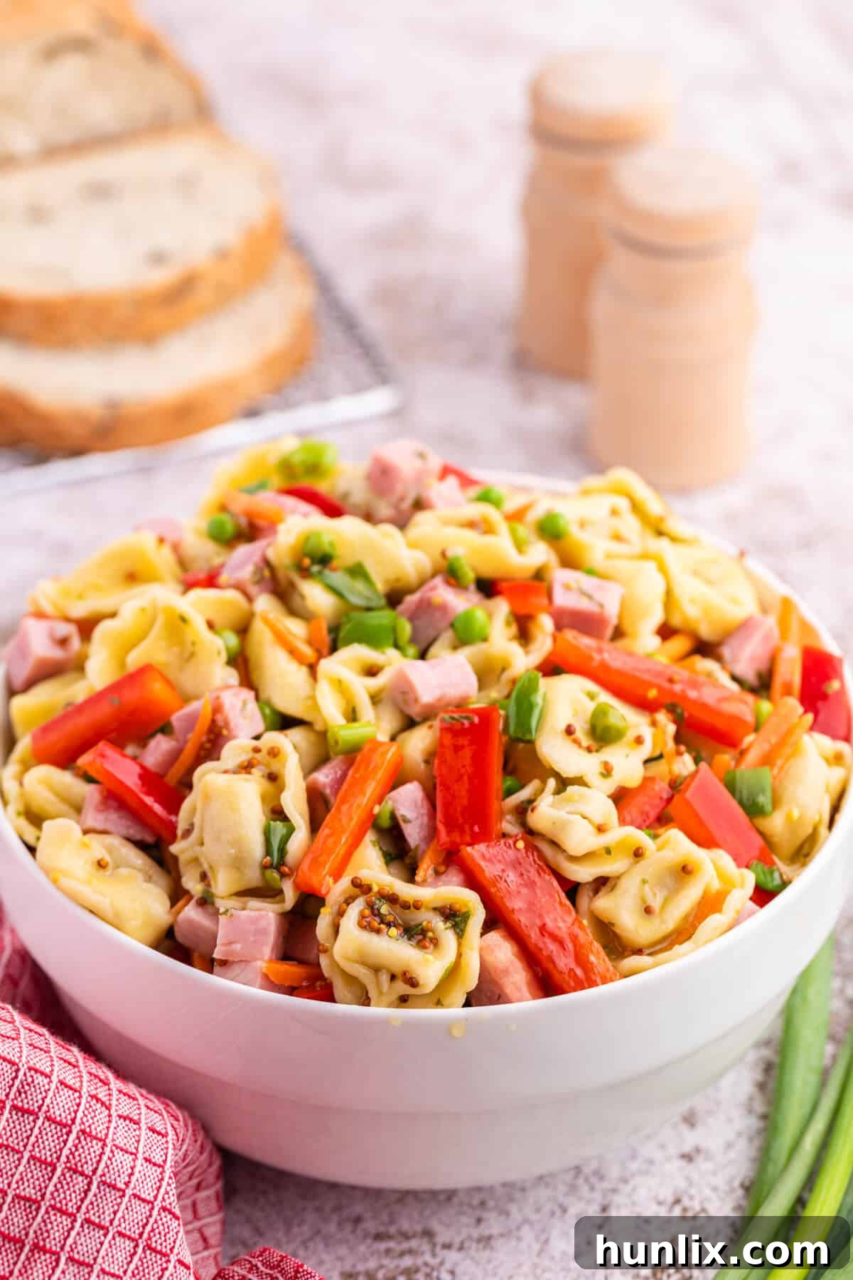 Tortellini salad served in a elegant white bowl, ready for enjoyment.