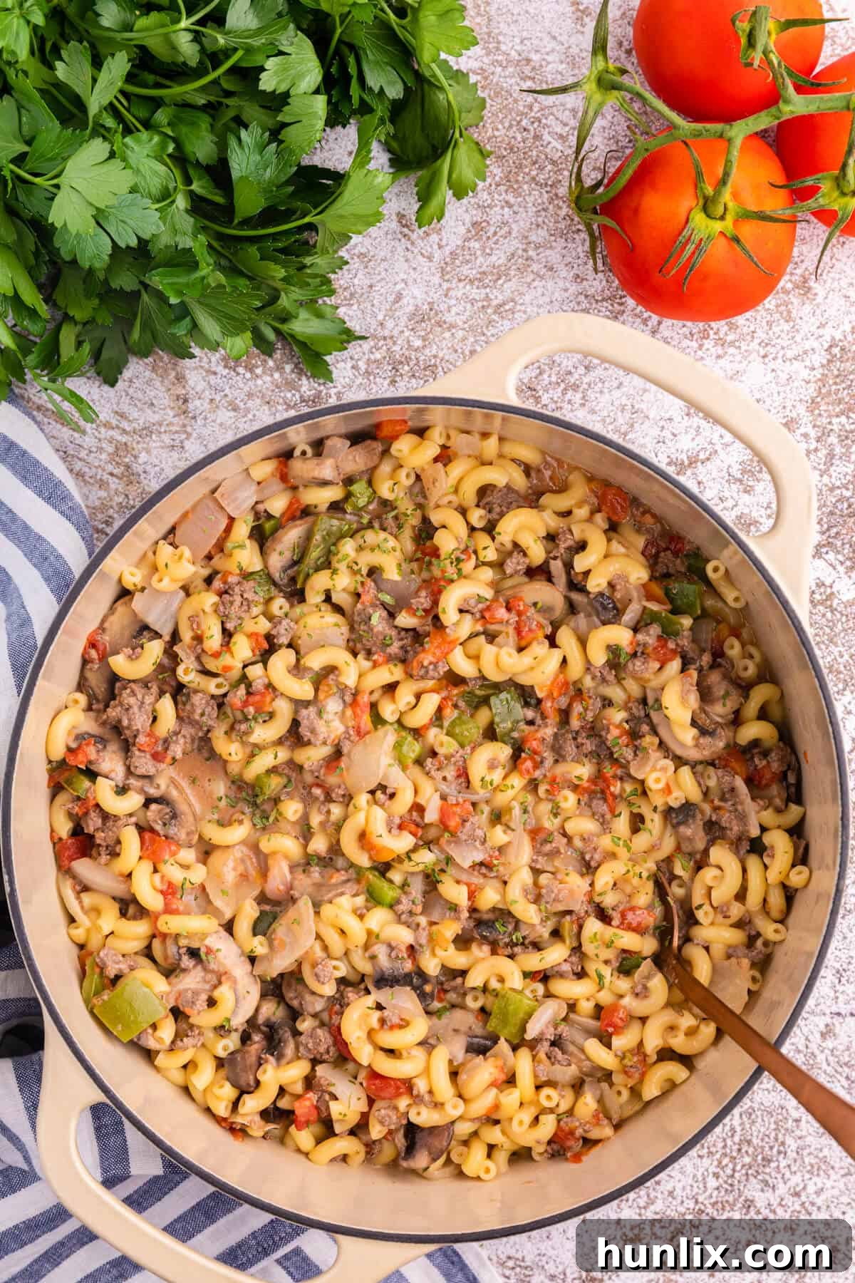 Mom's Heartwarming Macaroni 2 Mom's Macaroni, a comforting ground beef and pasta casserole, served in a pot with a spoon.