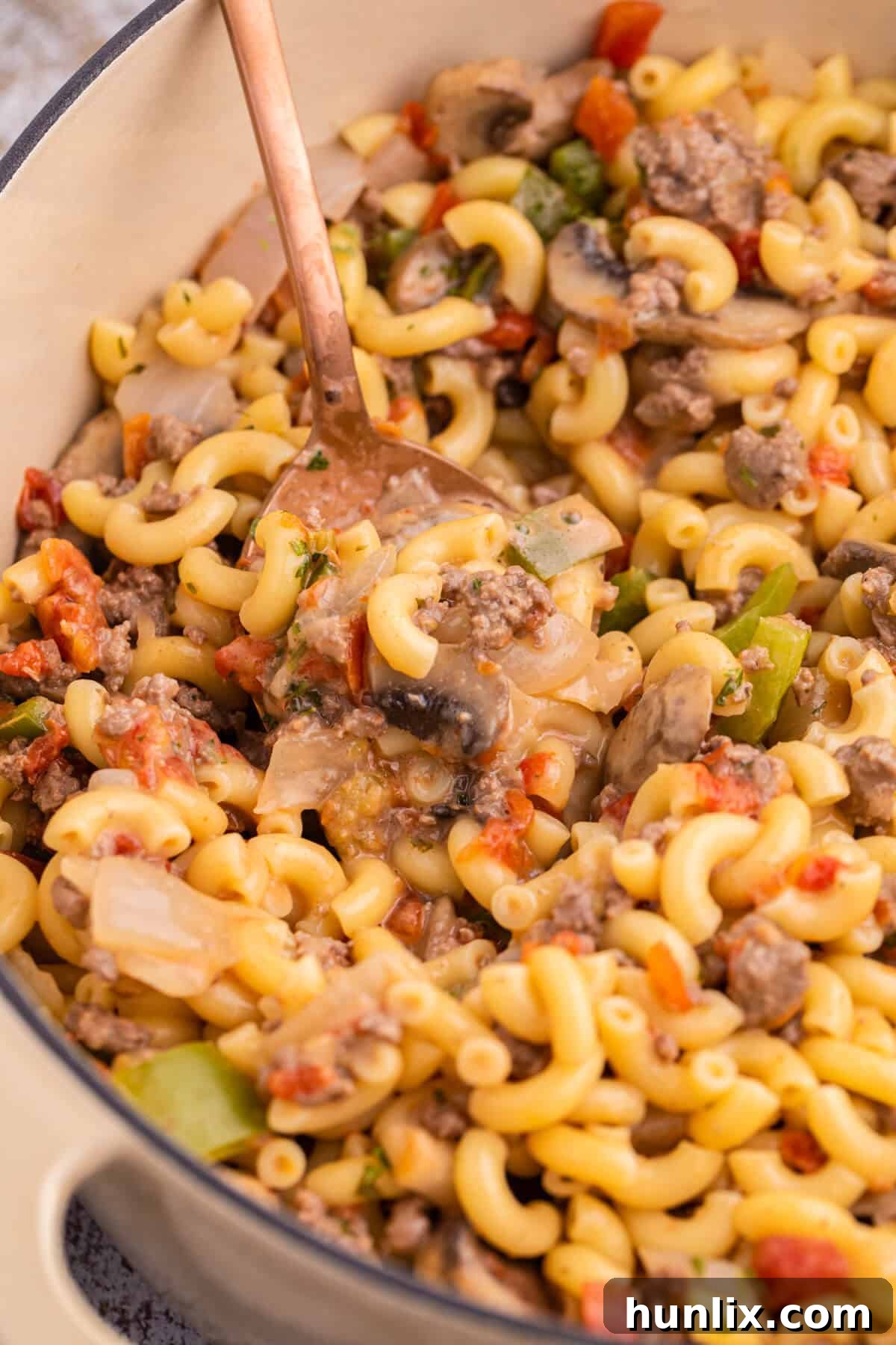 Mom's Heartwarming Macaroni 3 A generous serving of Mom's Macaroni in a pot, ready to be scooped with a large serving spoon.