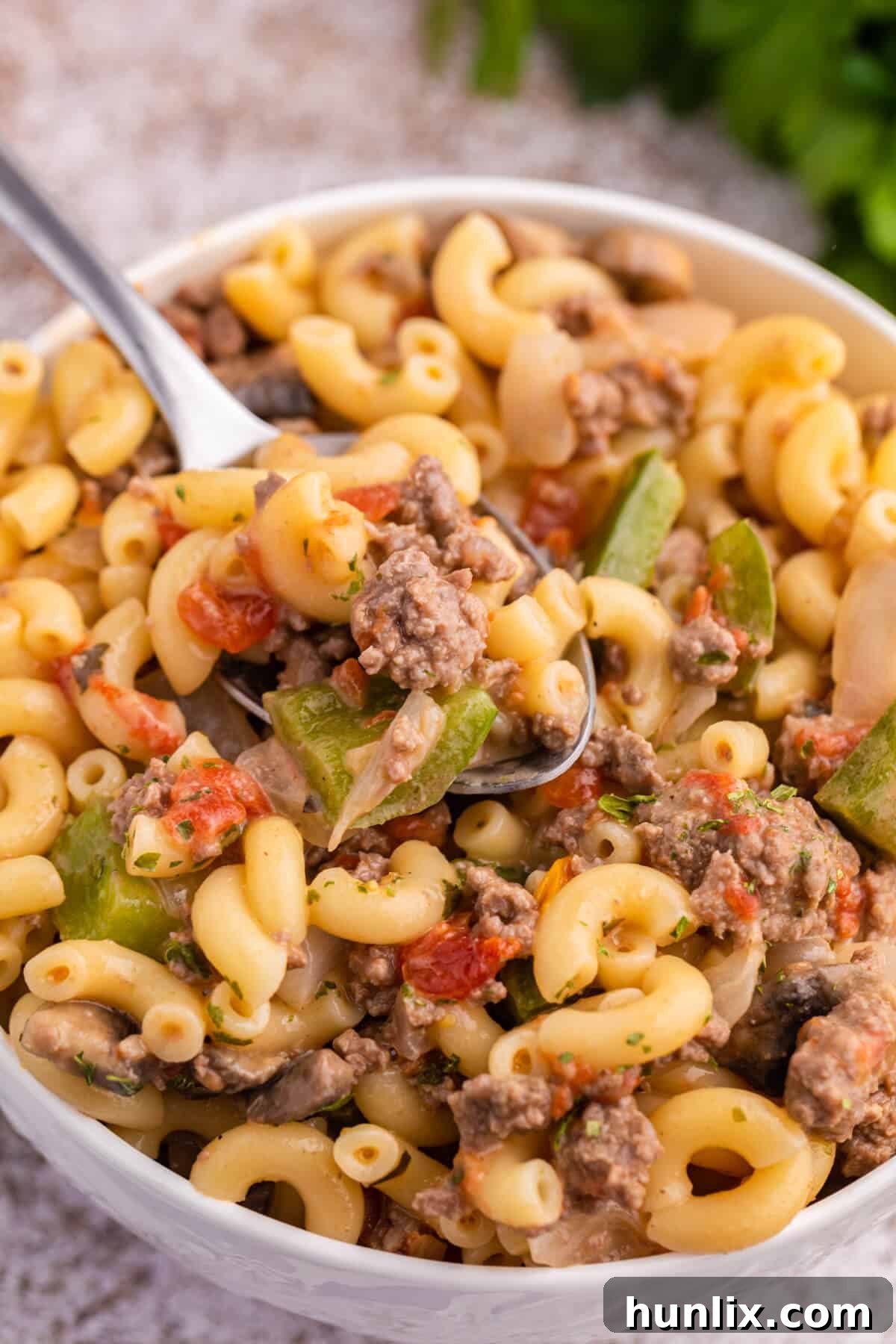 Mom's Heartwarming Macaroni 6 A comforting bowl of Mom's Macaroni with a spoon, ready to be enjoyed.