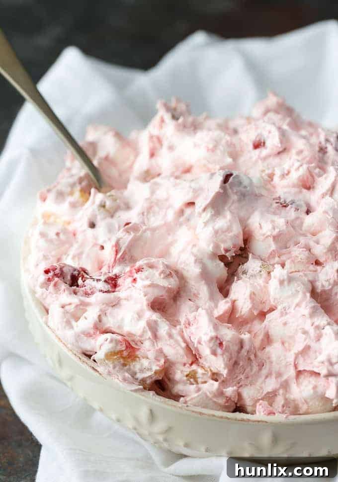 A bowl of Cherry Salad ready to be served, garnished with a single cherry.