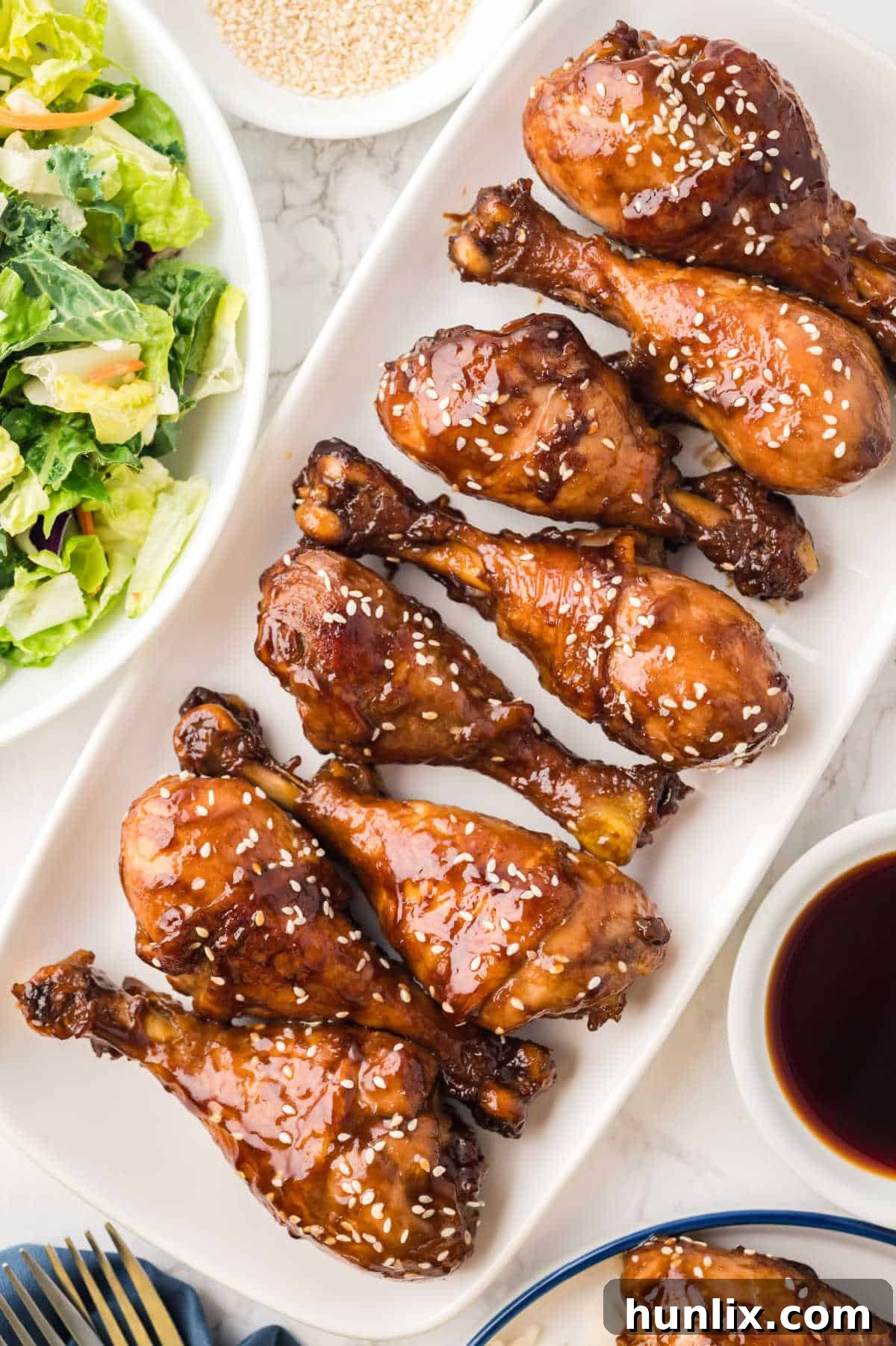 Sticky chicken drumsticks arranged neatly on a white platter, ready to be served.