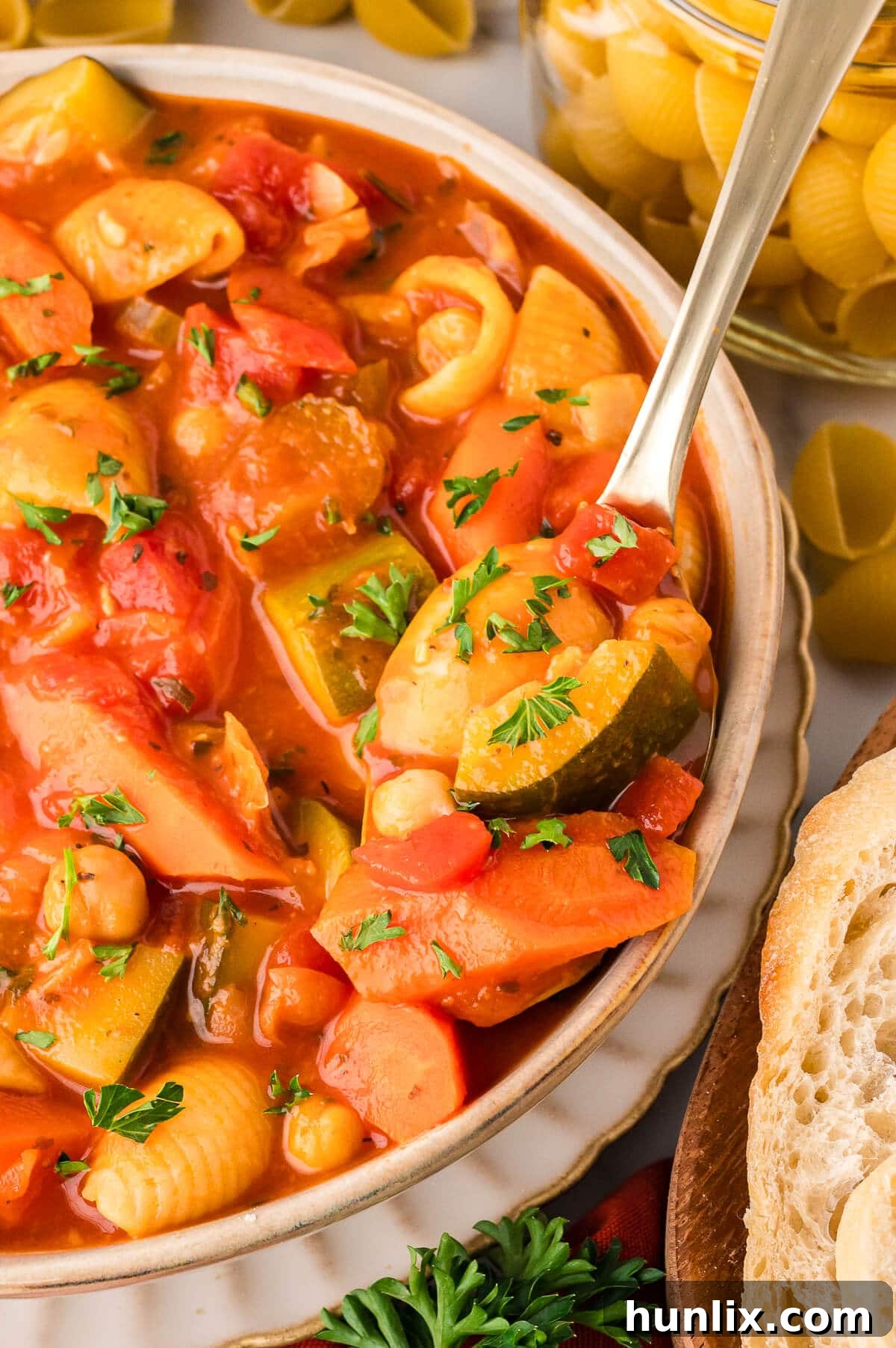 Hearty Italian Vegetable and Pasta Soup 7 A close-up shot of a bowl of minestrone soup with a spoon, showing the rich texture and colorful vegetables, garnished with fresh parsley.