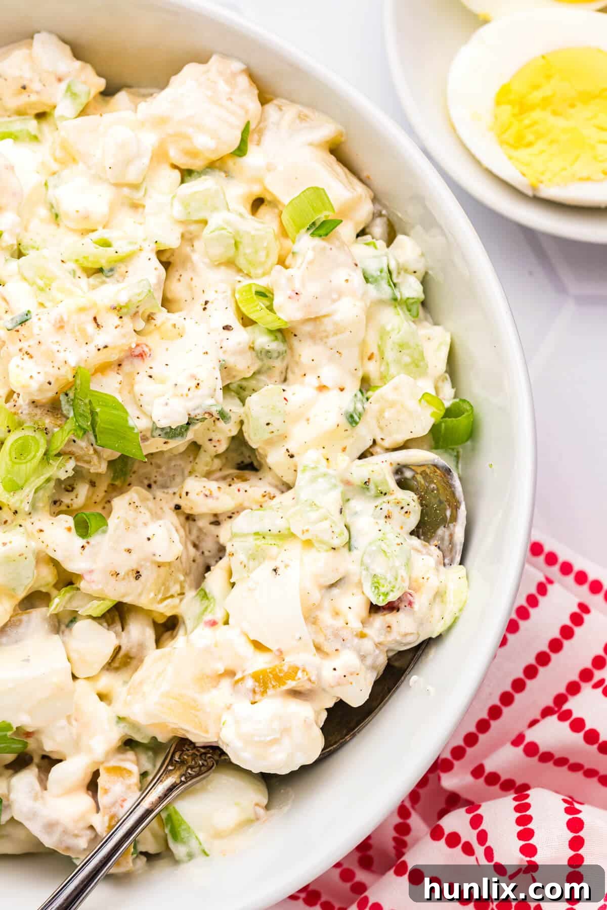 A full bowl of luscious cheese potato salad, perfectly chilled and ready for serving.