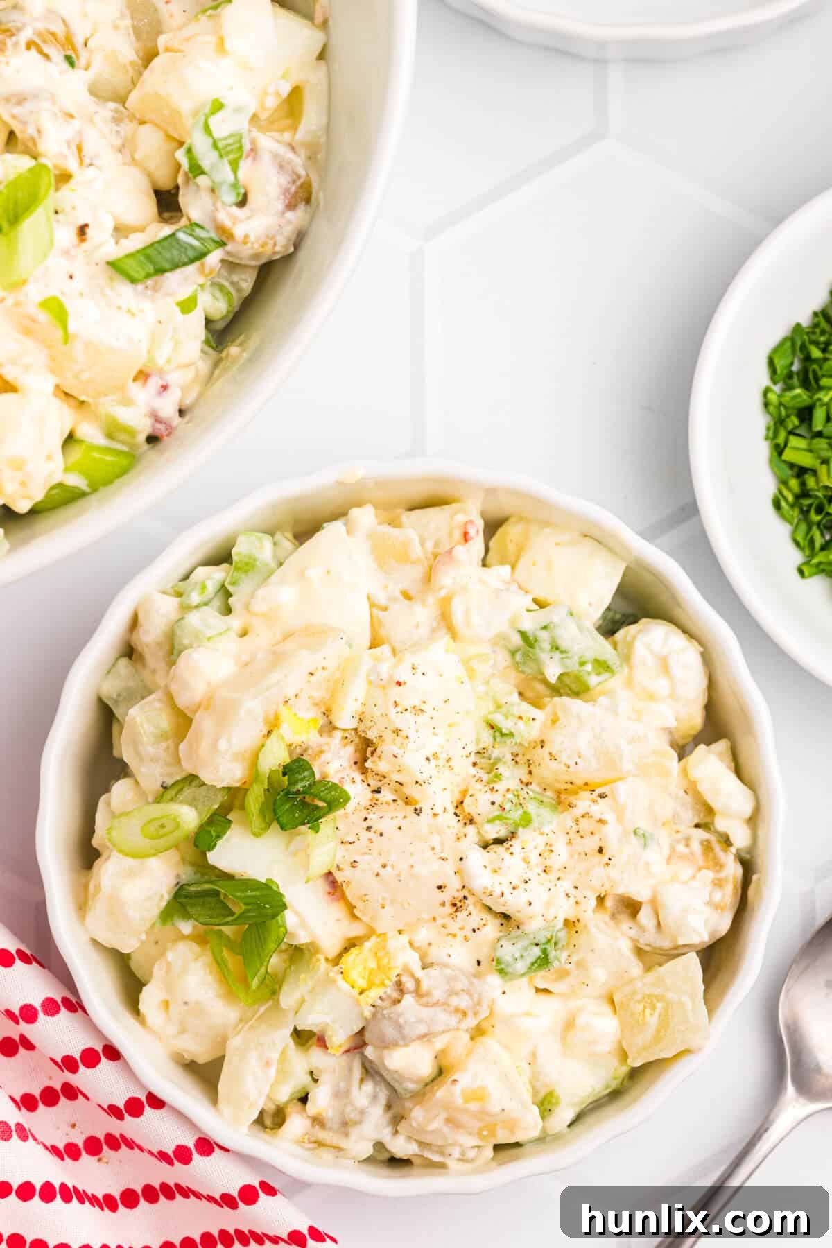 A beautifully presented bowl of creamy cheese potato salad, ready for serving at any gathering.