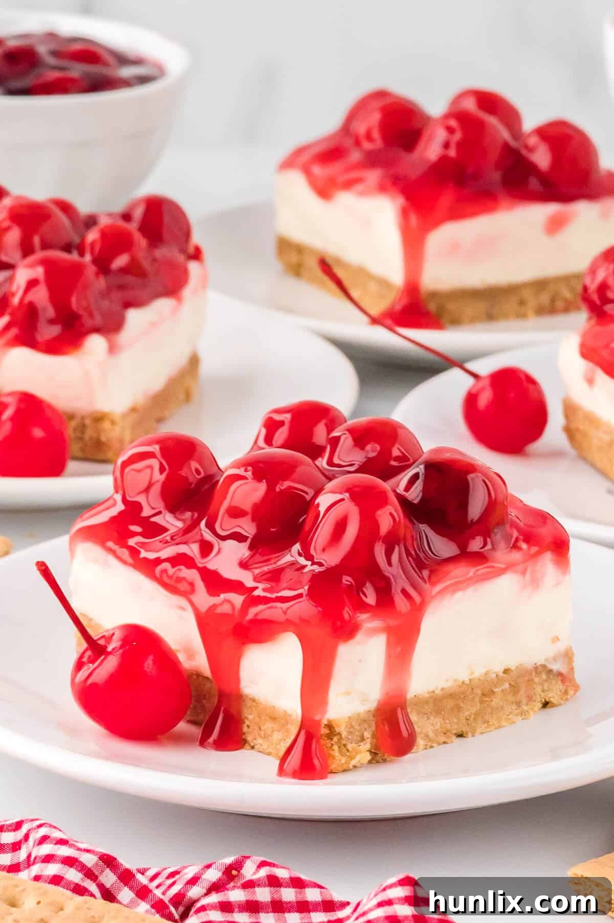 A perfectly sliced piece of no-bake cherry cheesecake on a white plate, ready to be enjoyed.