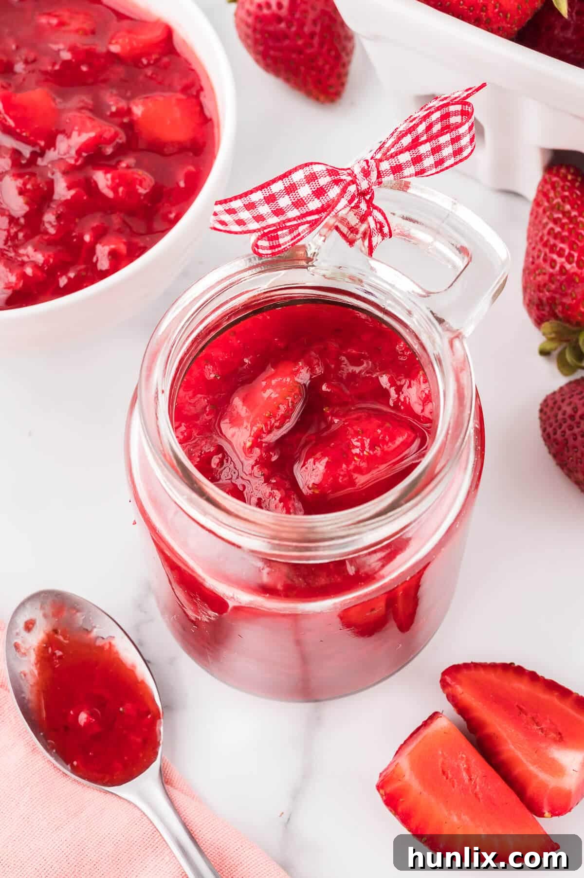 A jar of homemade strawberry sauce, ready for storage or immediate enjoyment.