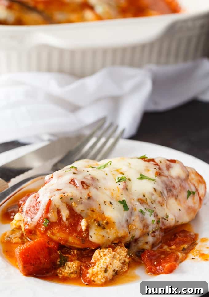 Lasagna Stuffed Chicken - Keto comfort food! Tender chicken breasts are stuffed with a ricotta filling and smothered in marinara sauce and mozzarella cheese.