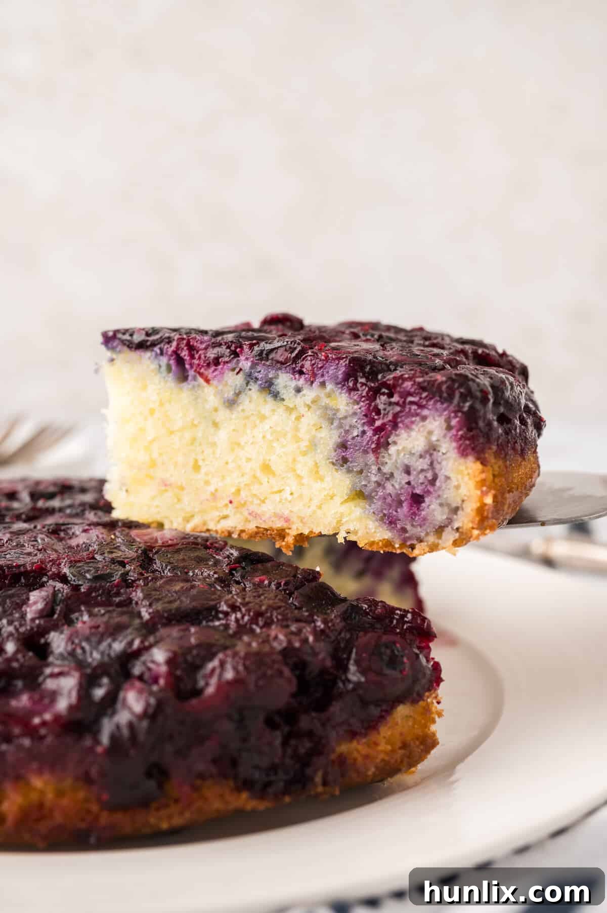 Inverted Blueberry Bliss 7 A perfectly baked slice of blueberry upside down cake presented on a spatula, ready to be served.