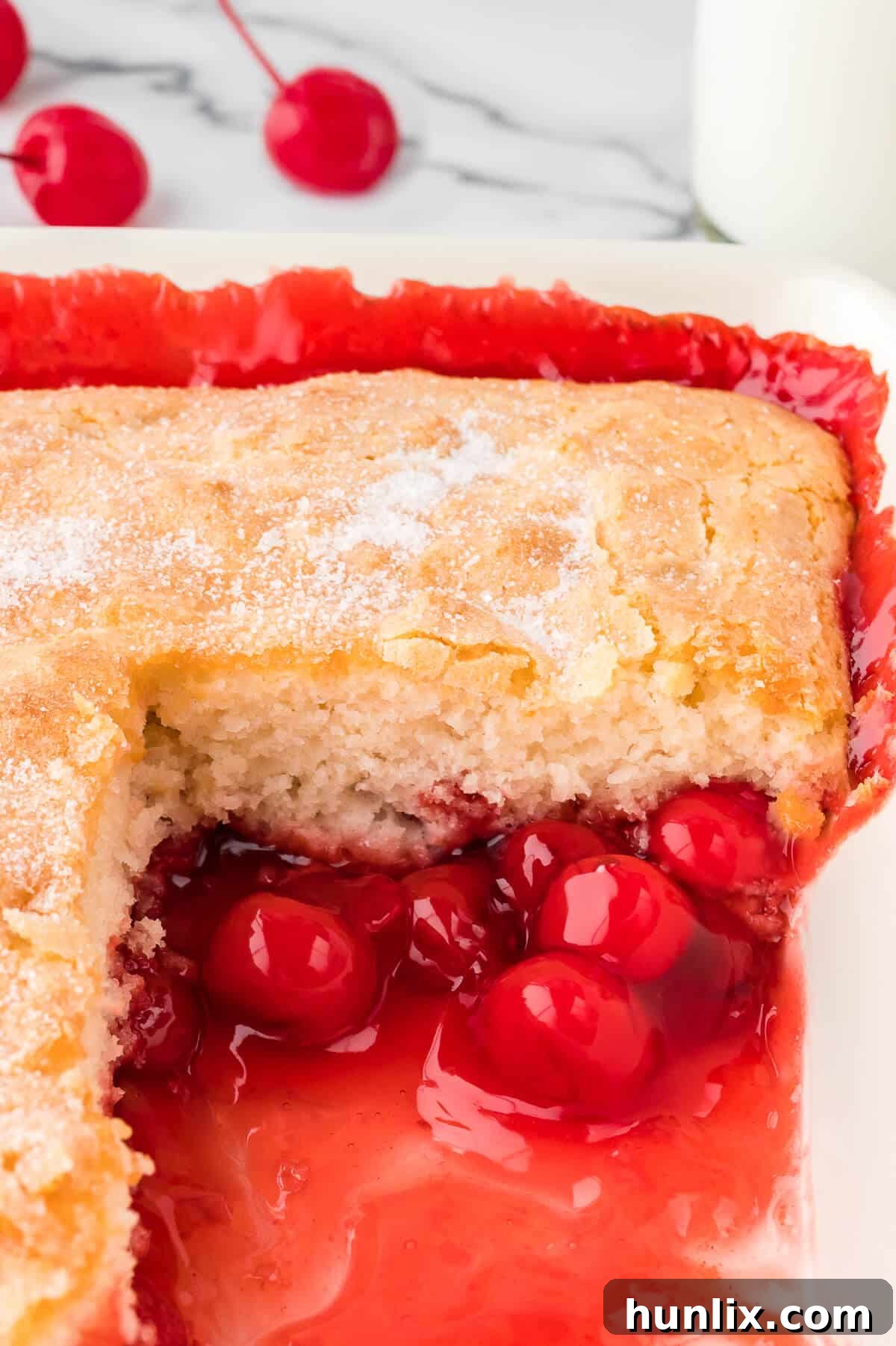 Velvet Cherry Pudding Cake 6 The recipe in a pan with a piece cut out.