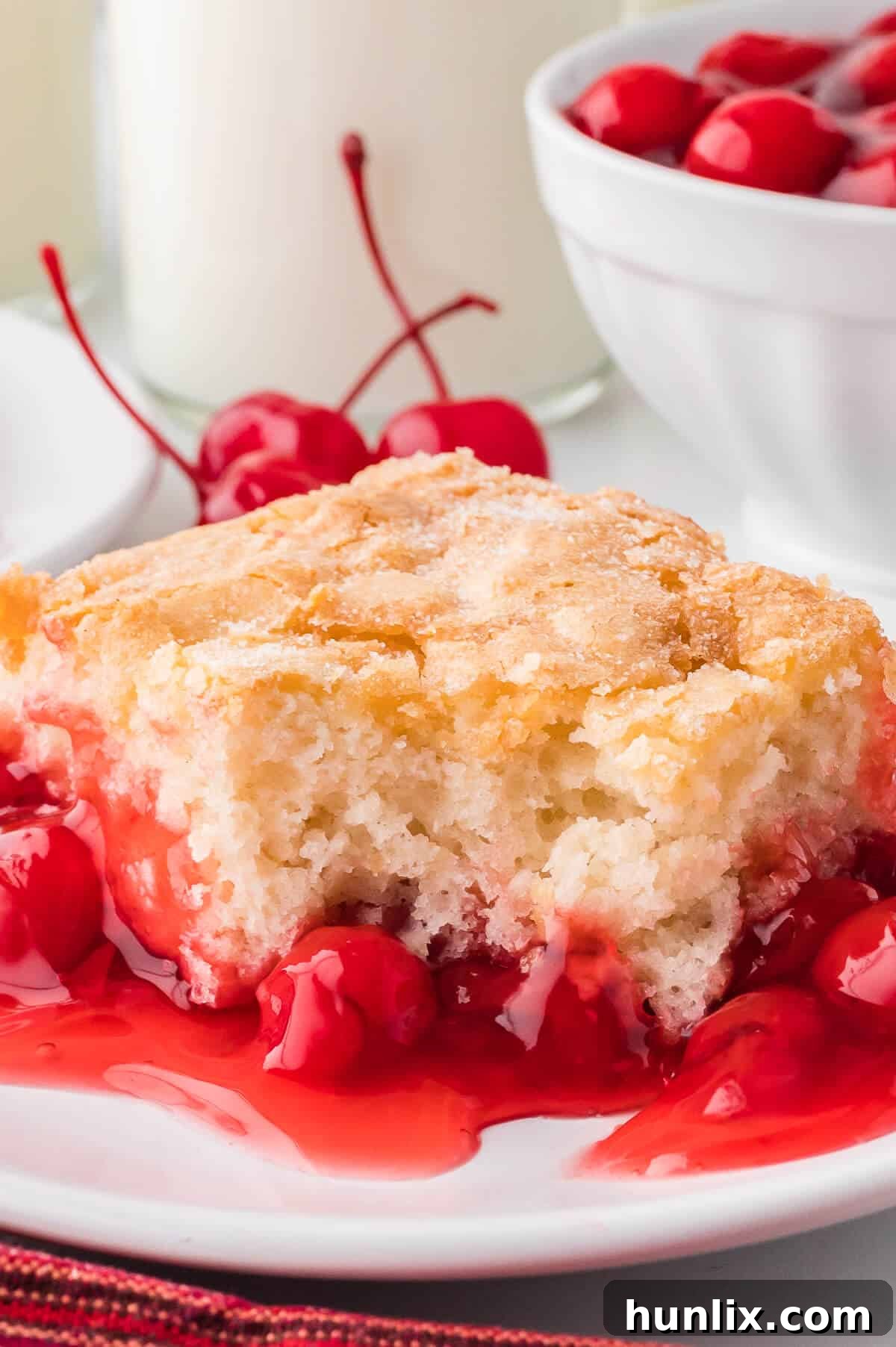 Velvet Cherry Pudding Cake 8 A cake slice on a plate with a bite out of it.