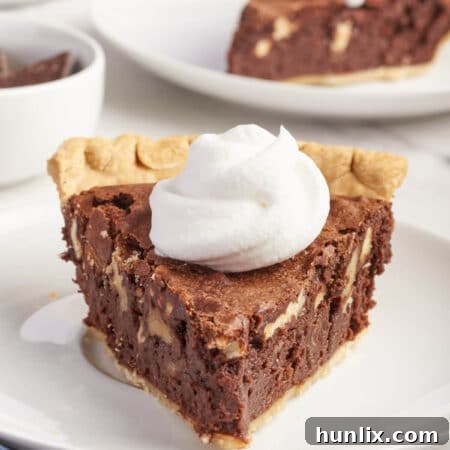 A slice of chocolate pecan pie on a plate.