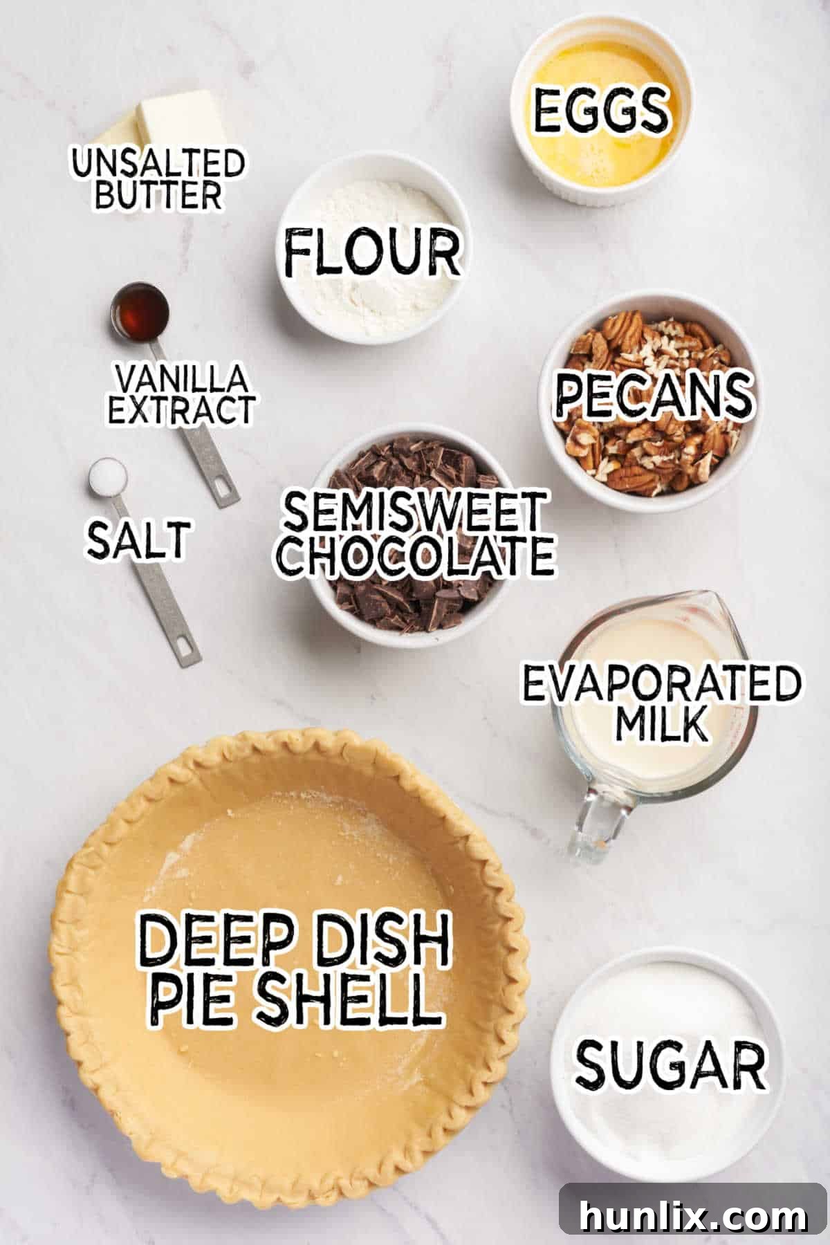 Decadent Chocolate Pecan Pie 3 A collection of ingredients for chocolate pecan pie laid out on a white surface.