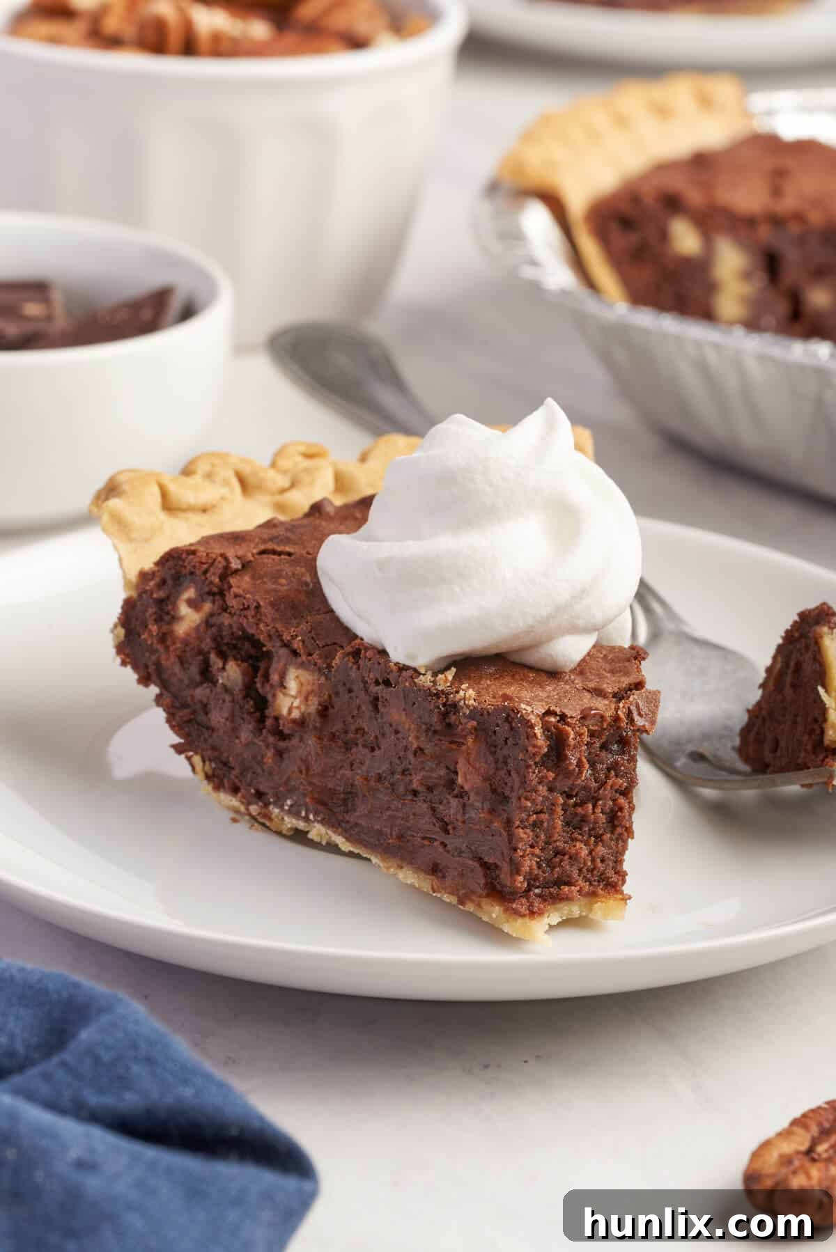 Decadent Chocolate Pecan Pie 9 A slice of chocolate pecan pie on a plate, with a small bite taken, highlighting the rich filling.