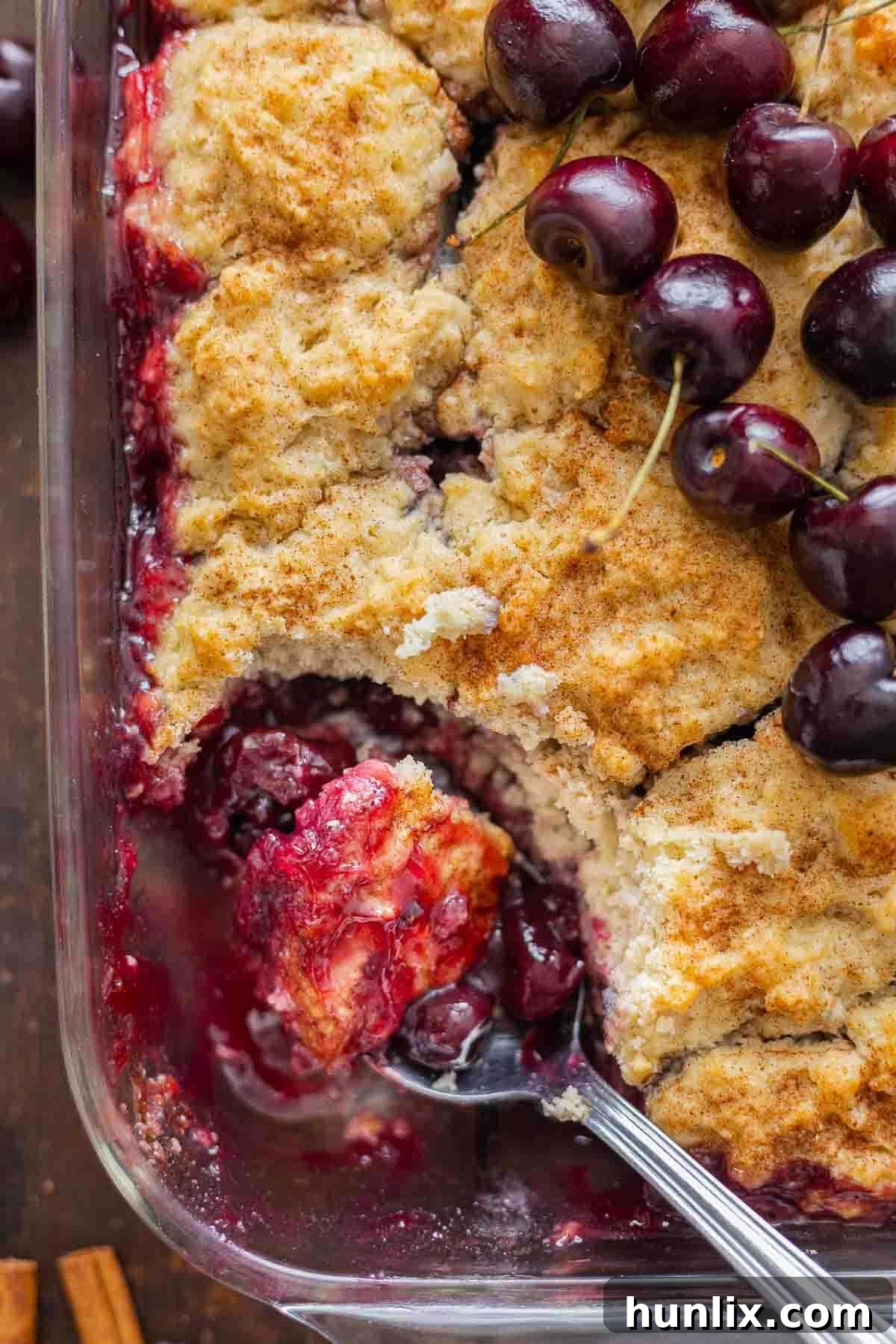 Fireside Cherry Cobbler 2 Winter cherry cobbler in a pan with a serving spoon.