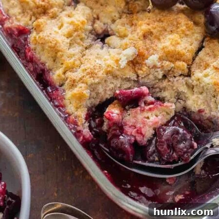 Fireside Cherry Cobbler 9 The recipe in a pan with a spoon.