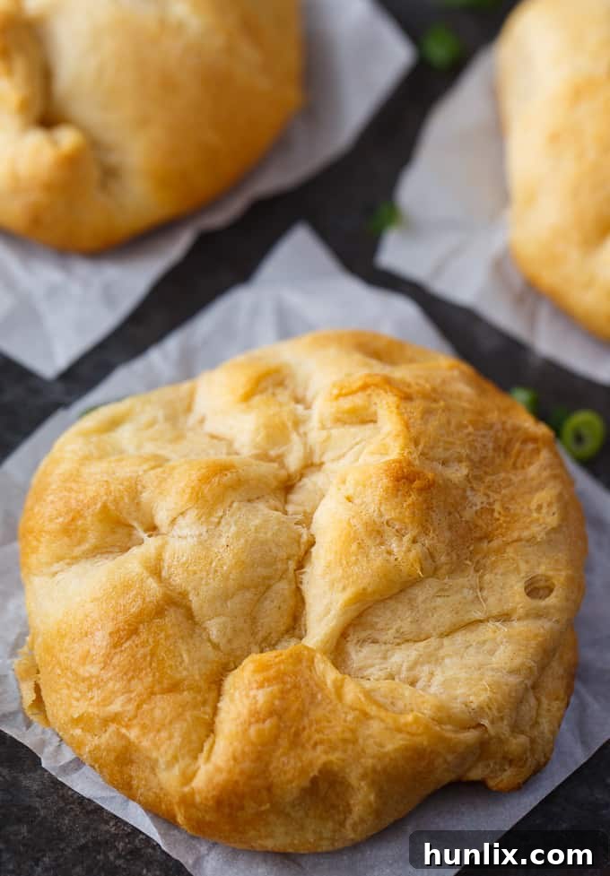 Golden Chicken Surprises 3 Close-up of golden brown chicken bundles on a baking sheet, showing their flaky texture and delicious filling.